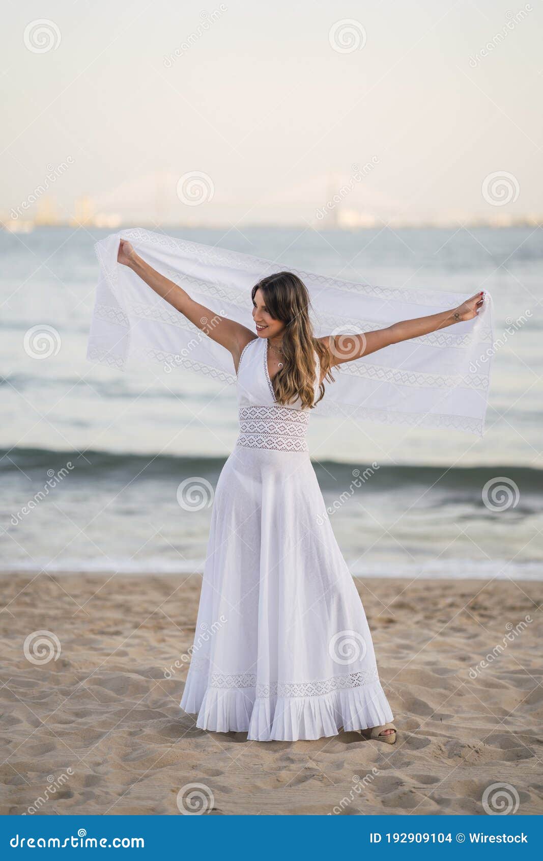 Mujer con vestido blanco en la playa.