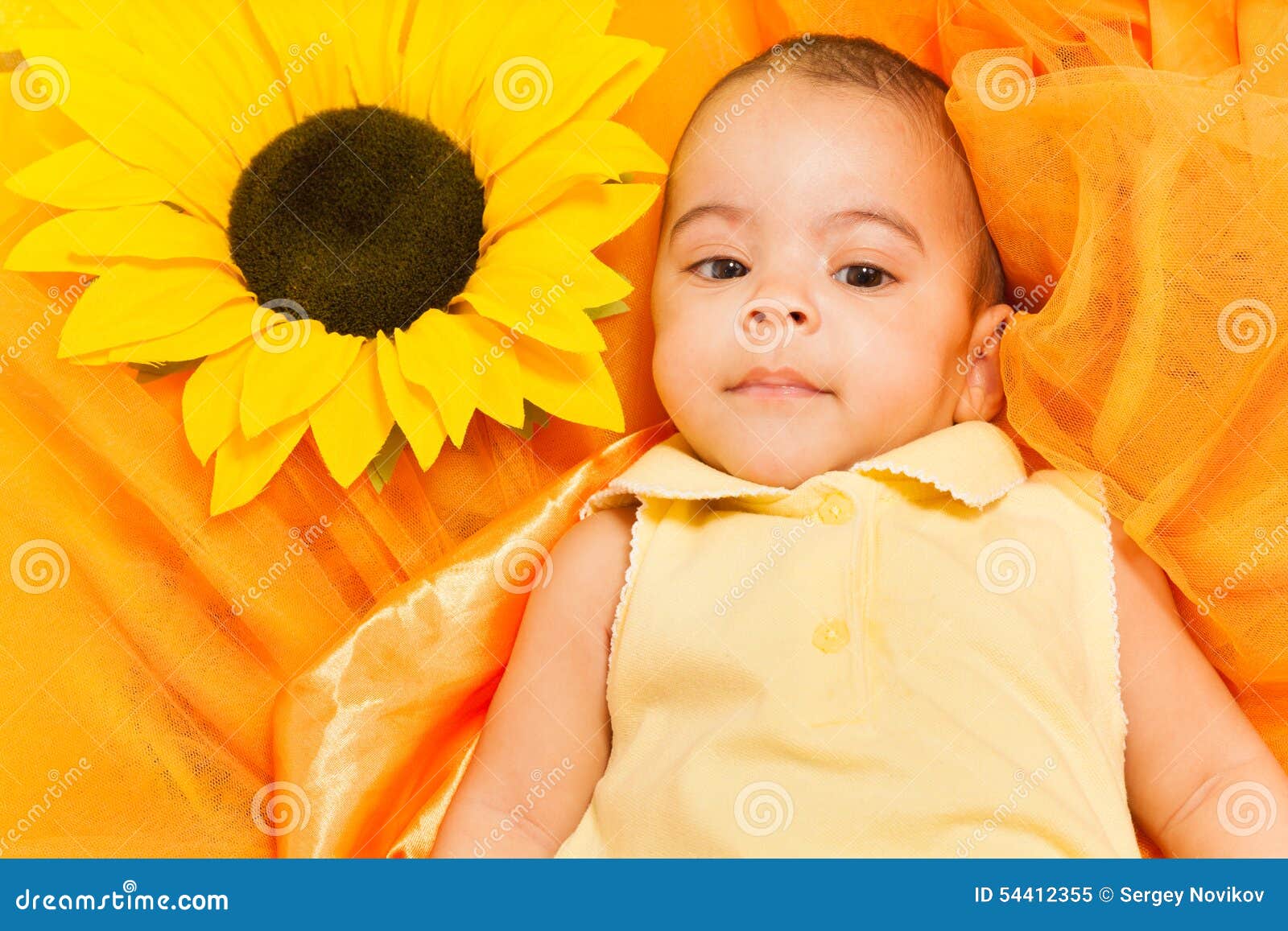 Retrato Del Bebé Africano Que Pone En El Paño Del Girasol Imagen de archivo  - Imagen de muchachas, adorable: 54412355