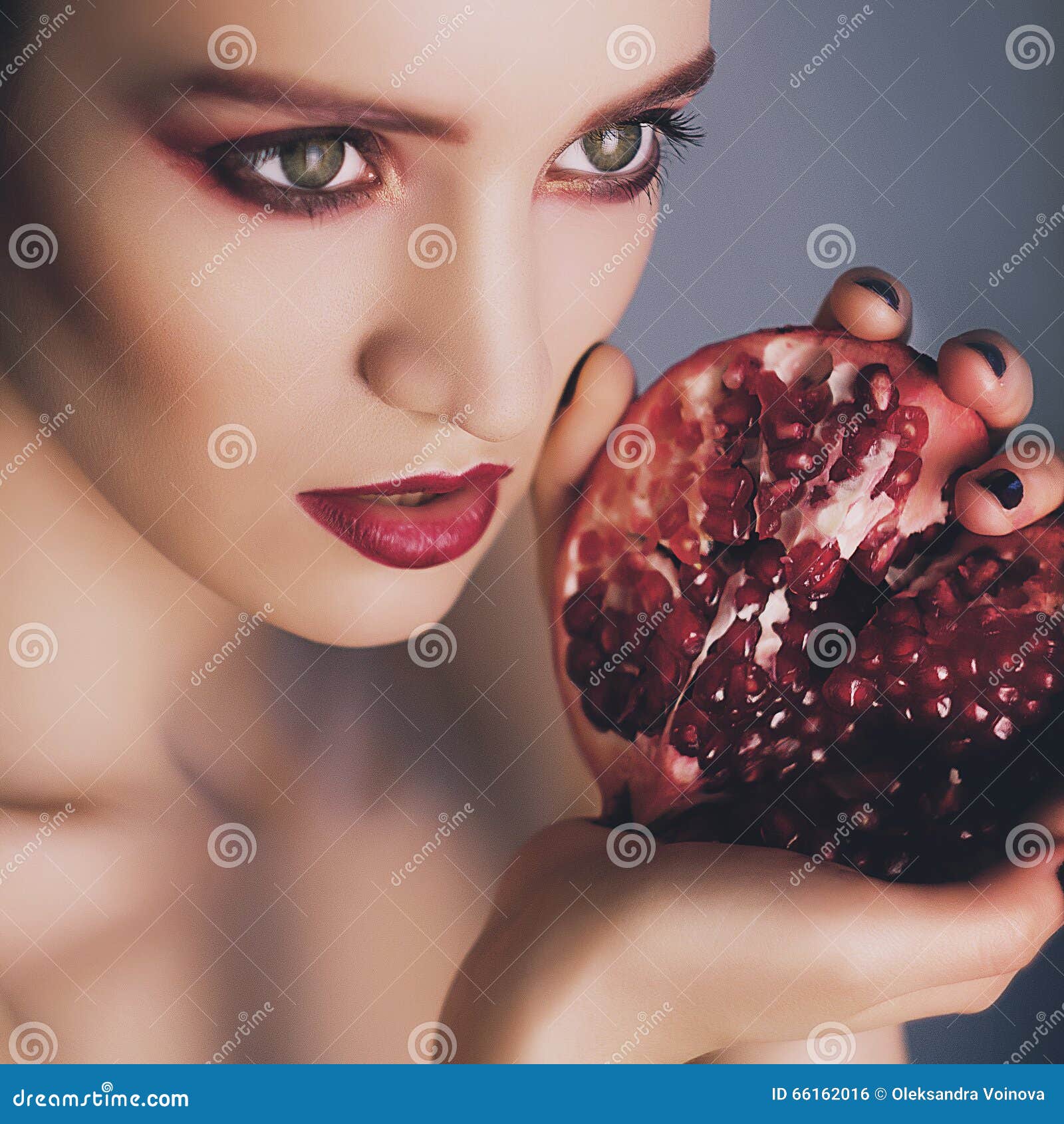 Retrato del modelo de moda atractivo hermoso con granate en manos 