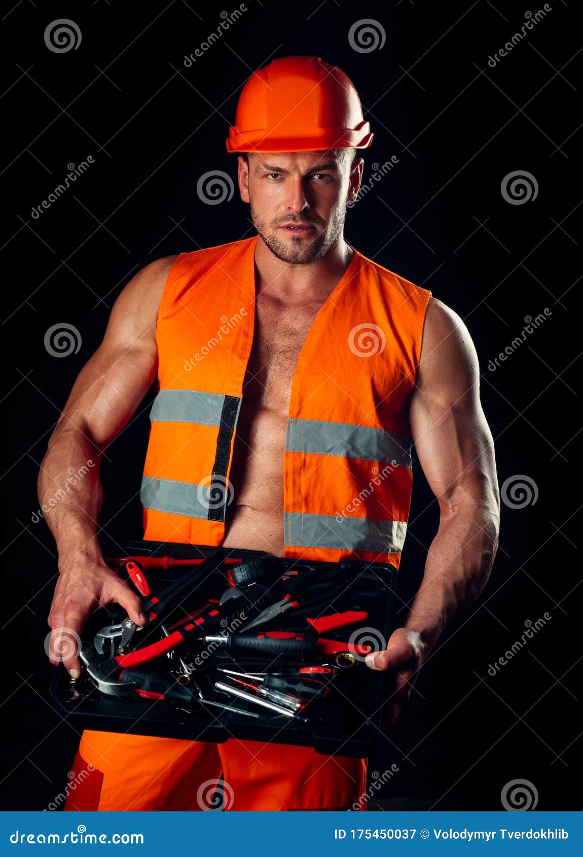 Un hombre con barba, casco y ropa de trabajo. retrato de un trabajador en  ropa de trabajo con espacio para copiar.