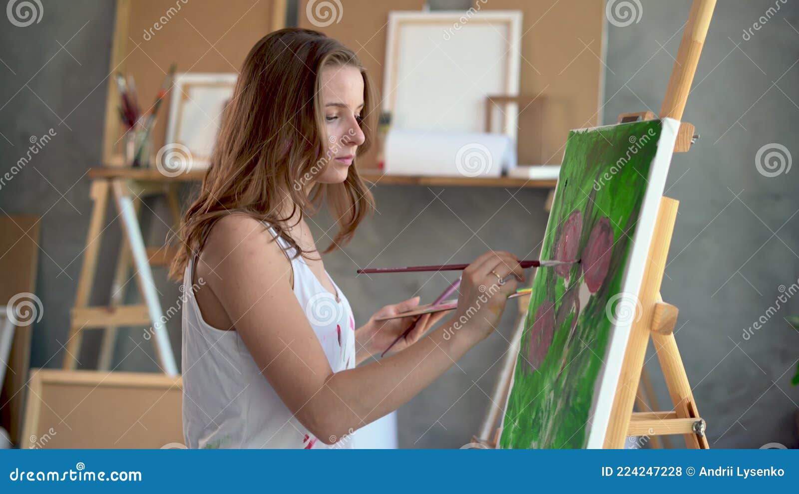 Uma mulher pintando um quadro em uma tela.