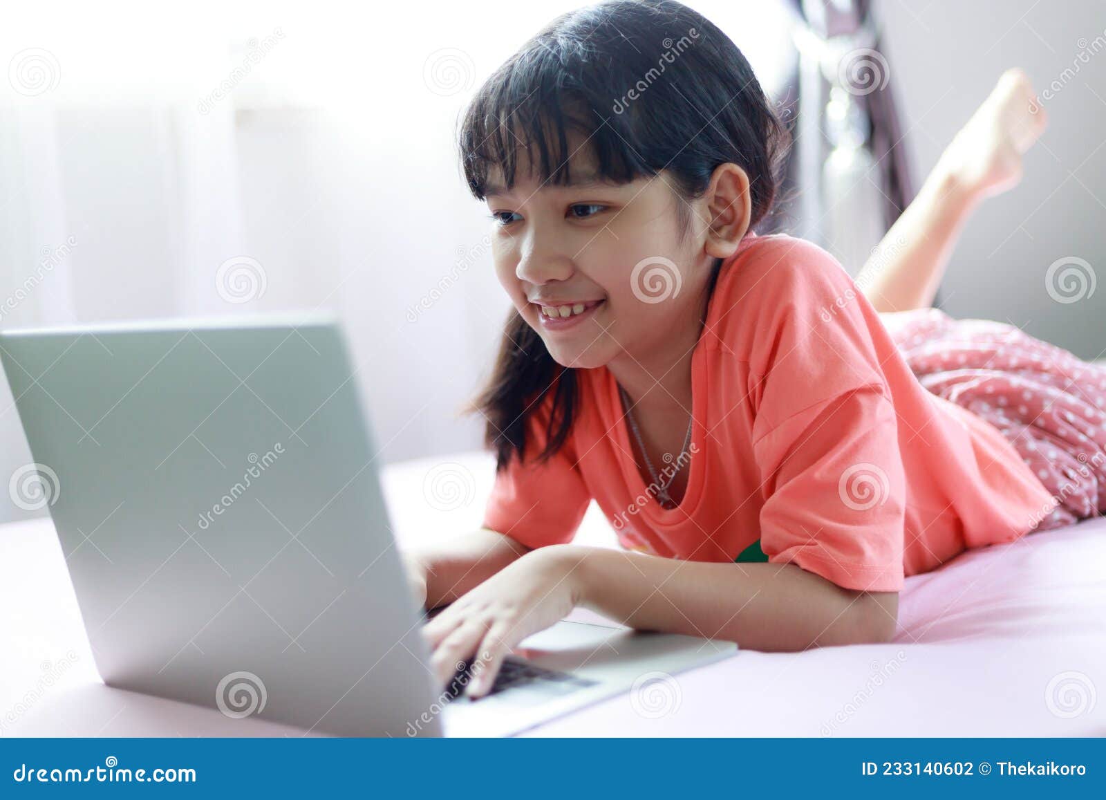 Muito jovem asiática gosta de digitar no laptop com um sorriso e