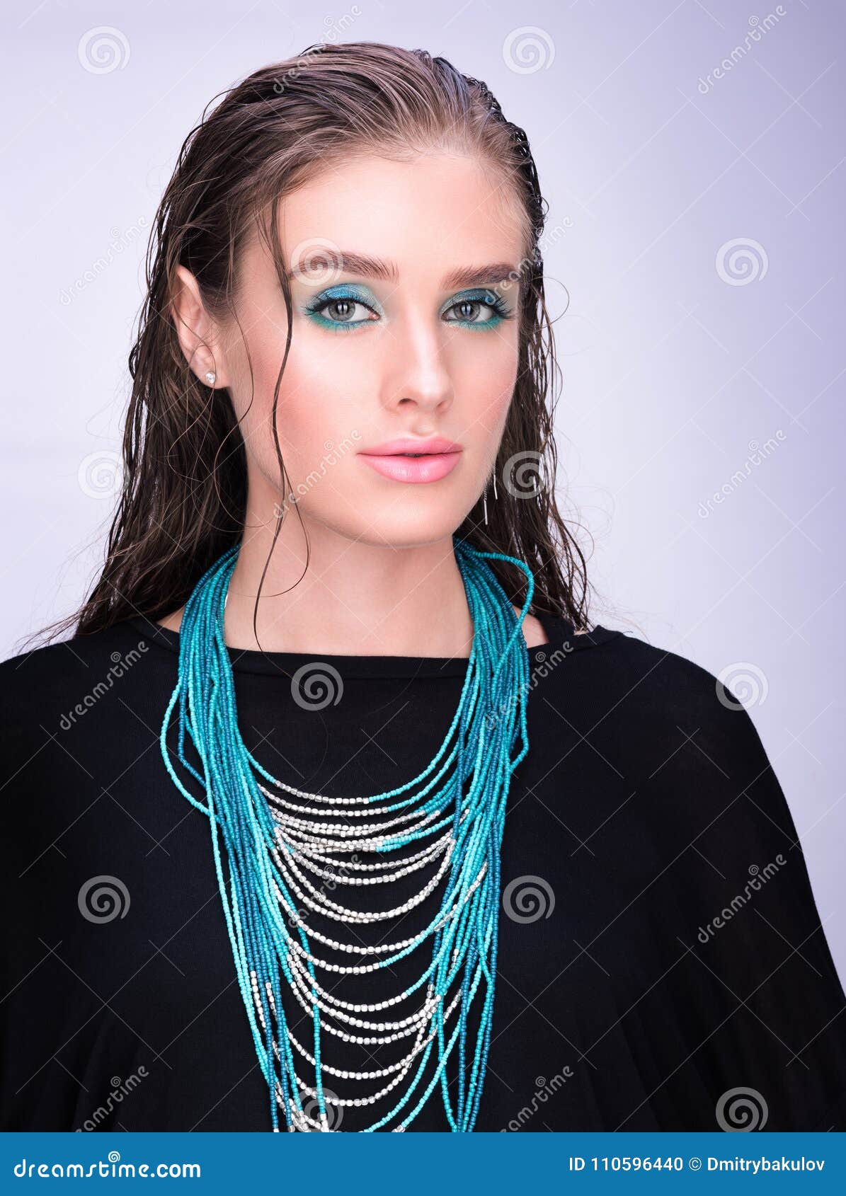 Retrato vertical de uma jovem mulher no preto Cabelo molhado e composição profissional Olhar sensual Colar de turquesa