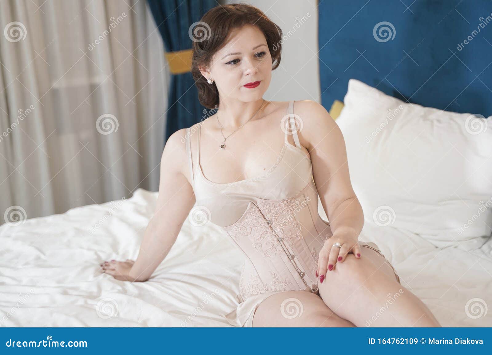 Retro Fifties Pin-up Attractive Girl in Vintage Lingerie on White Bed Background - Pin-up Concept Stock Image photo