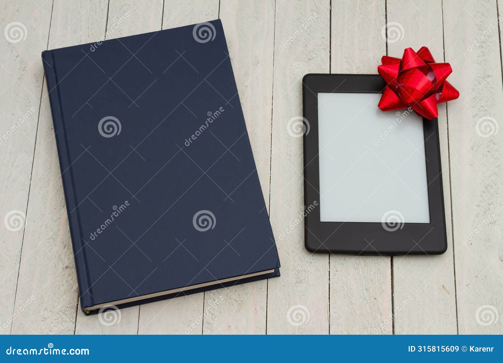 retro old blue book on a desk with an ereader with gift bow