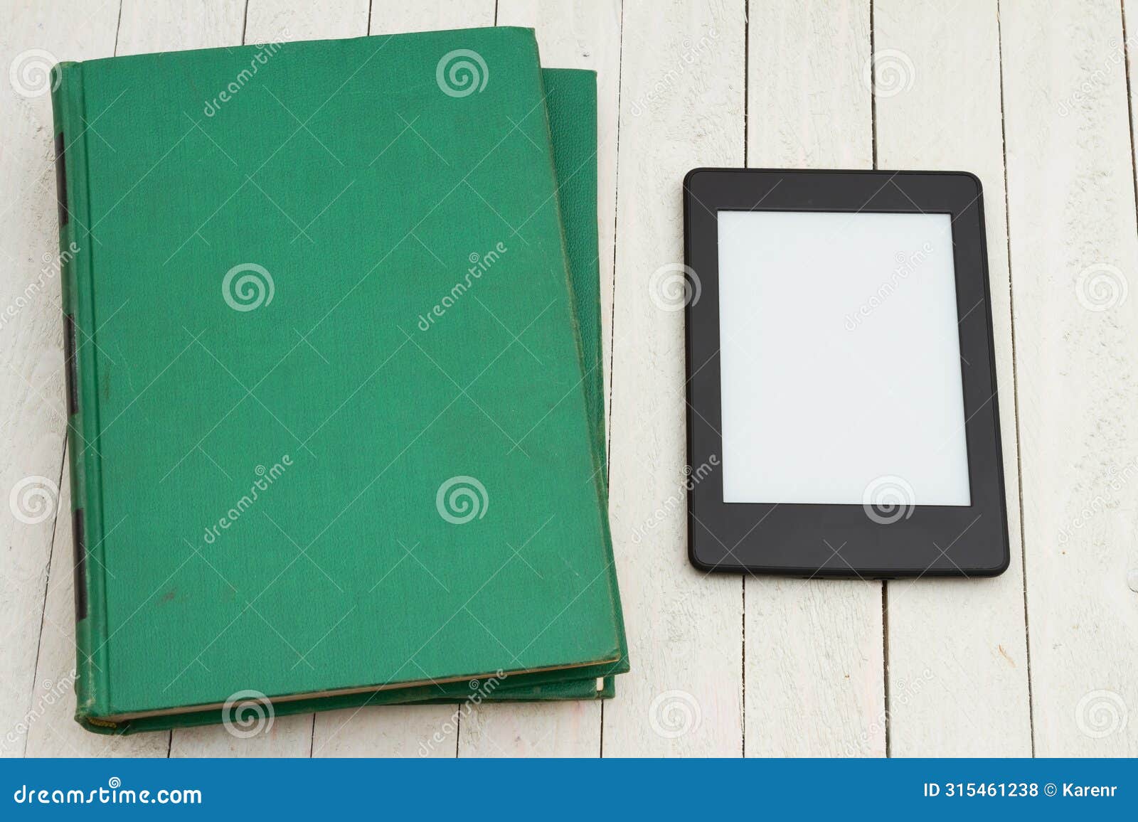 retro old green book on a desk with an ereader
