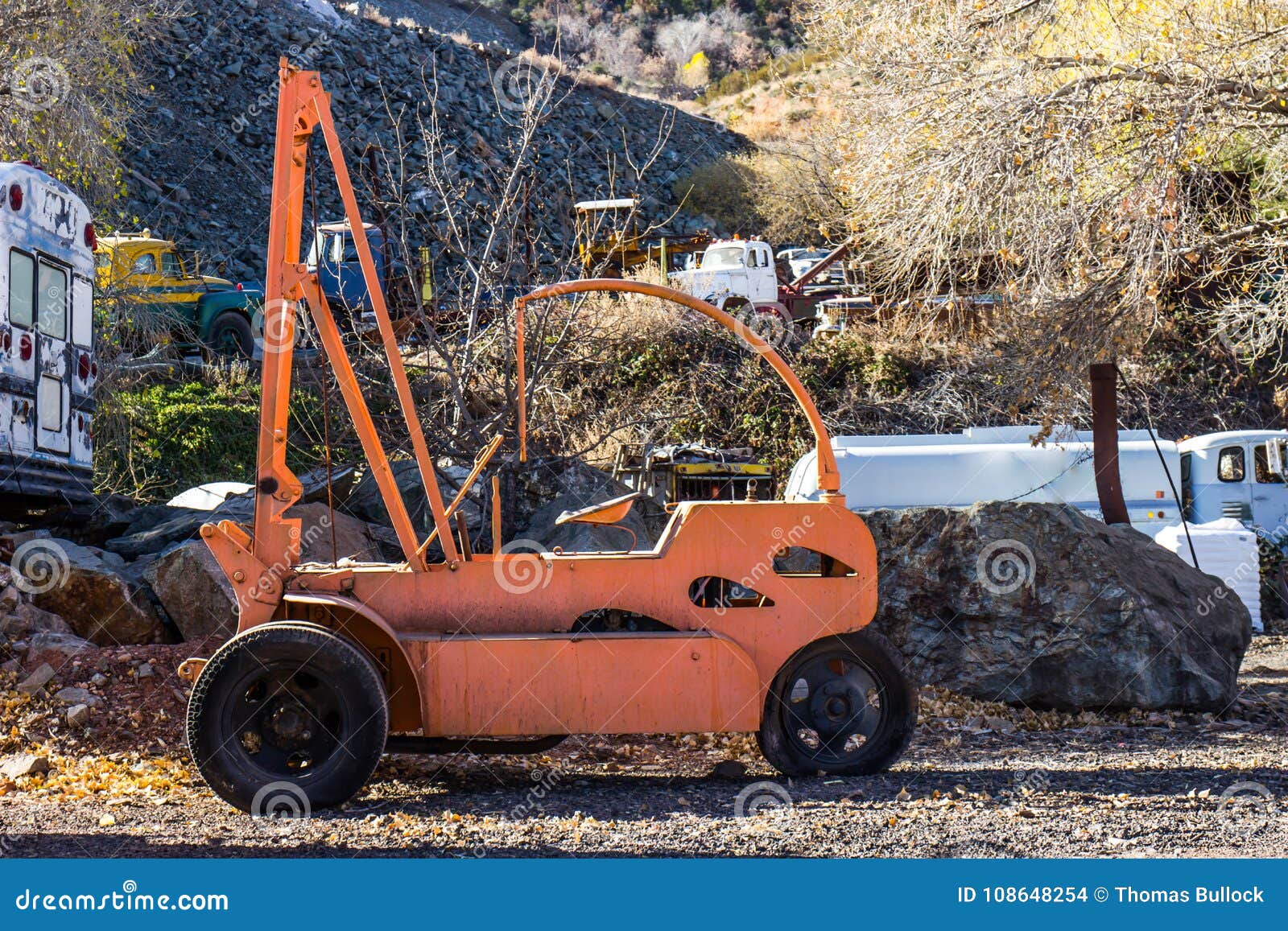 Retro Orange Fork Lift in Salvage Yard Stock Photo - Image of limbs