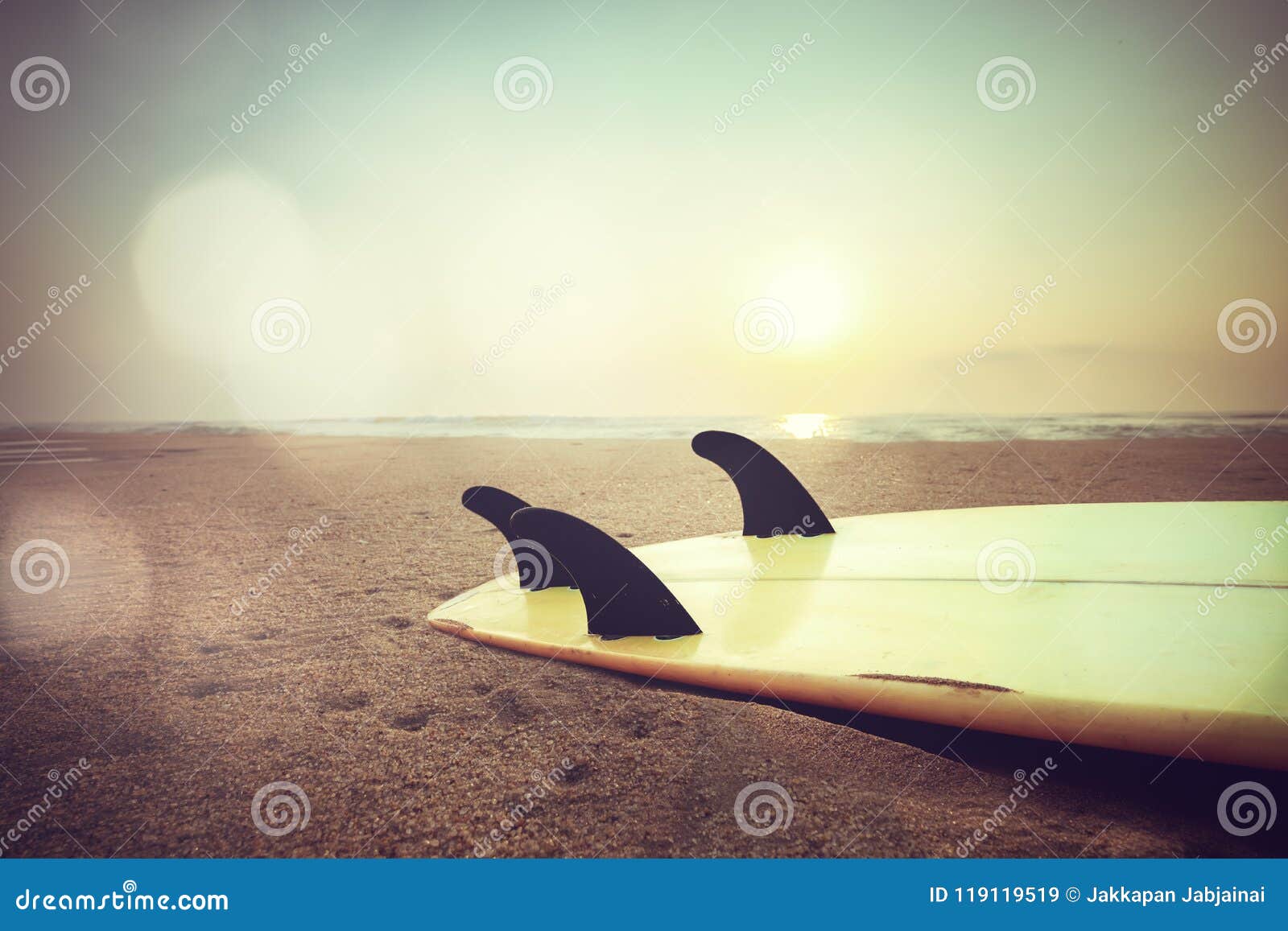 surfboard on beach at sunset
