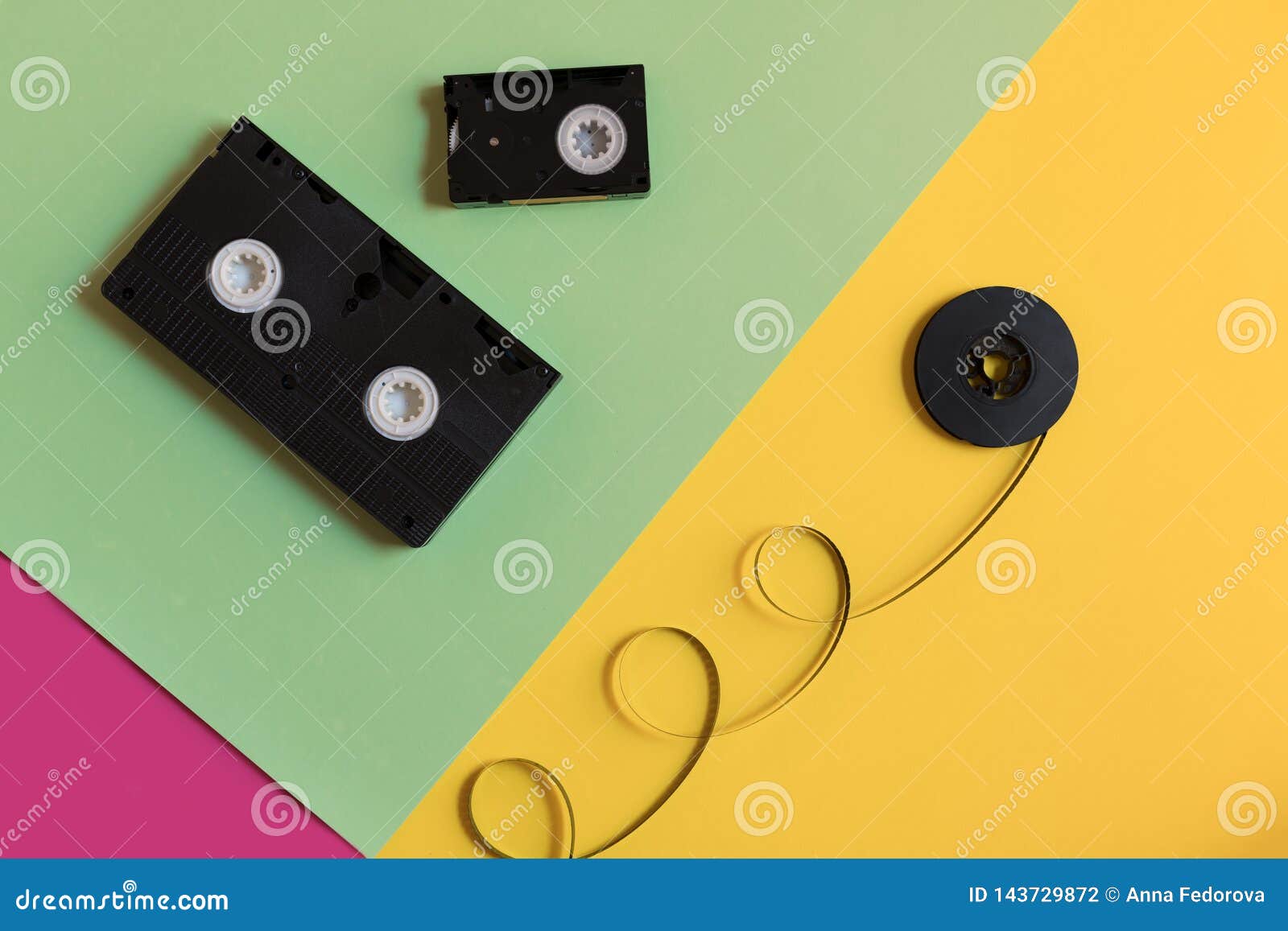 retro videocassette and film on a three-color pastel paper background. flat lay, minimal concept