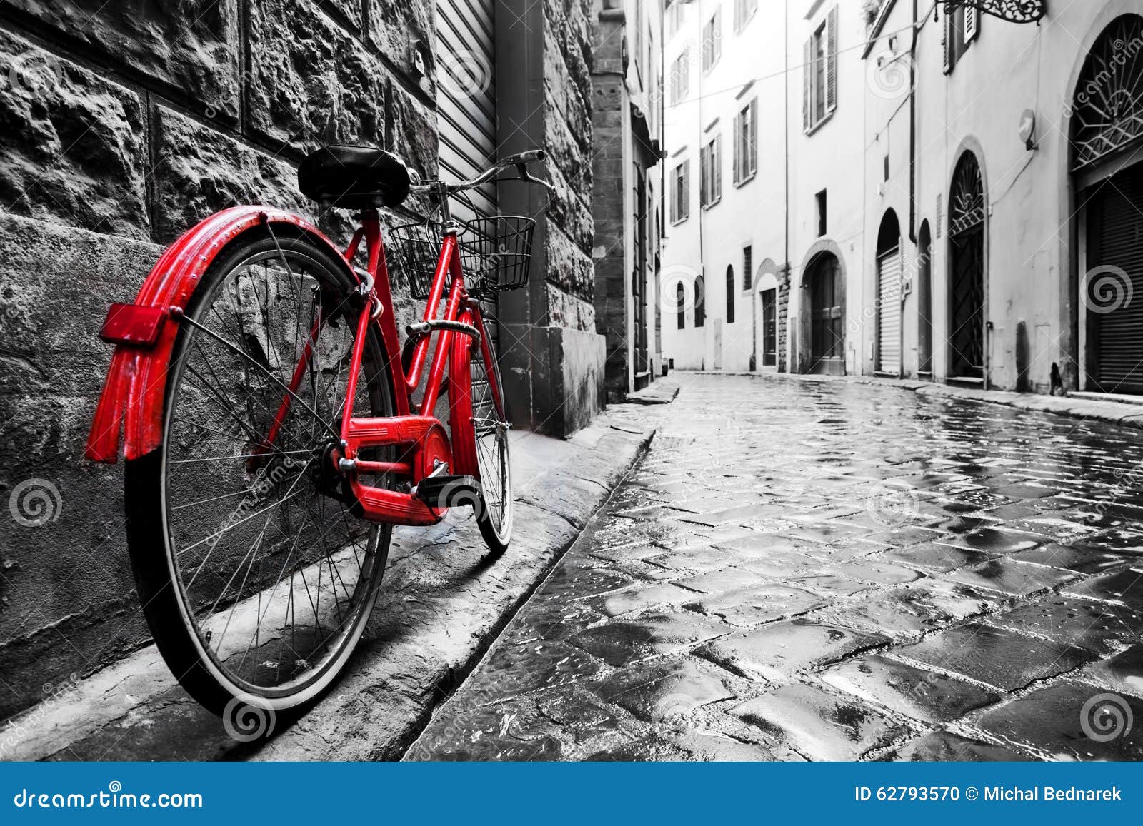 retro vintage red bike on cobblestone street in the old town. color in black and white