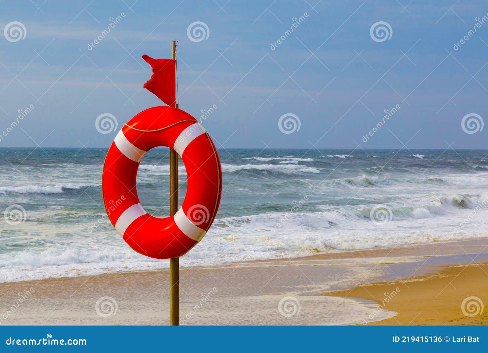 Rettungsring Und Rote Warnflagge Flattern Im Wind am Strand Bei