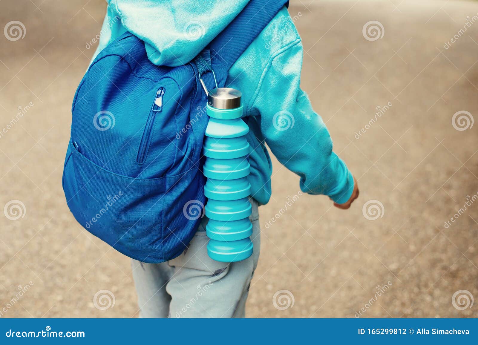 Reusable Blue Eco Friendly Water Bottle on Child`s Backpack Stock Photo