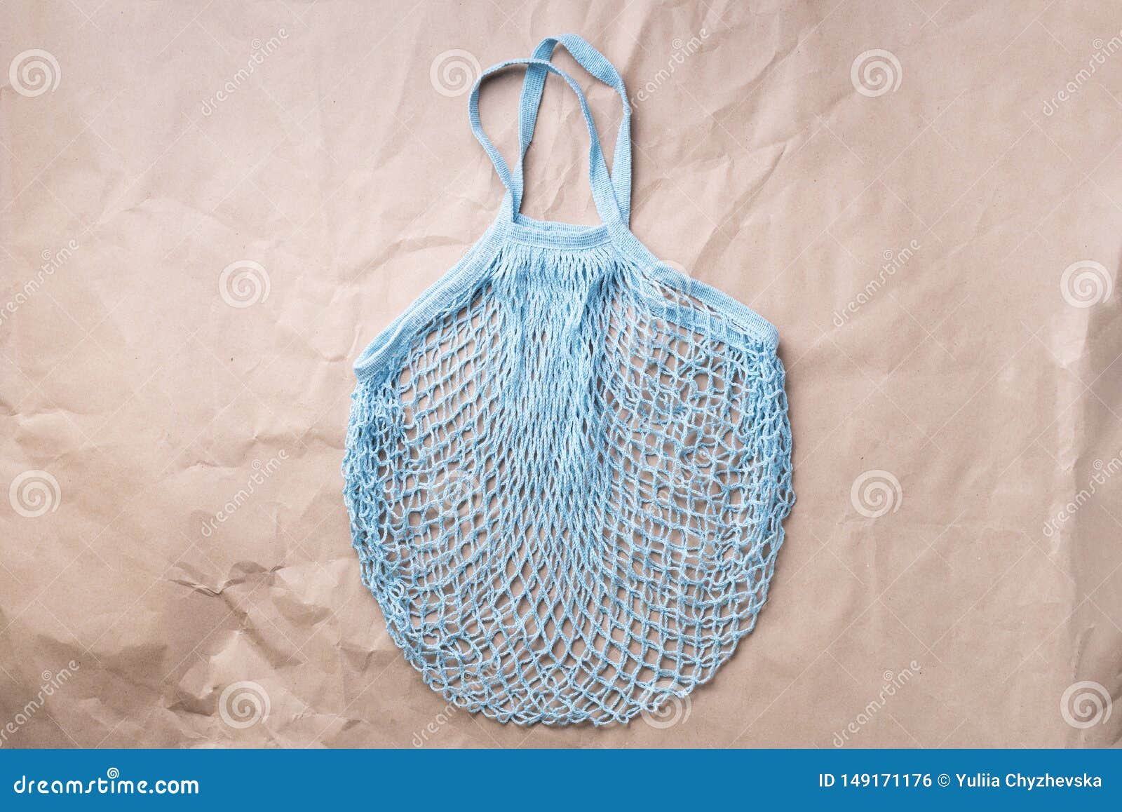 reusable net bag or mesh shopper on craft paper background. zero waste, plastic free concept. top view. eco friendly mesh shopper