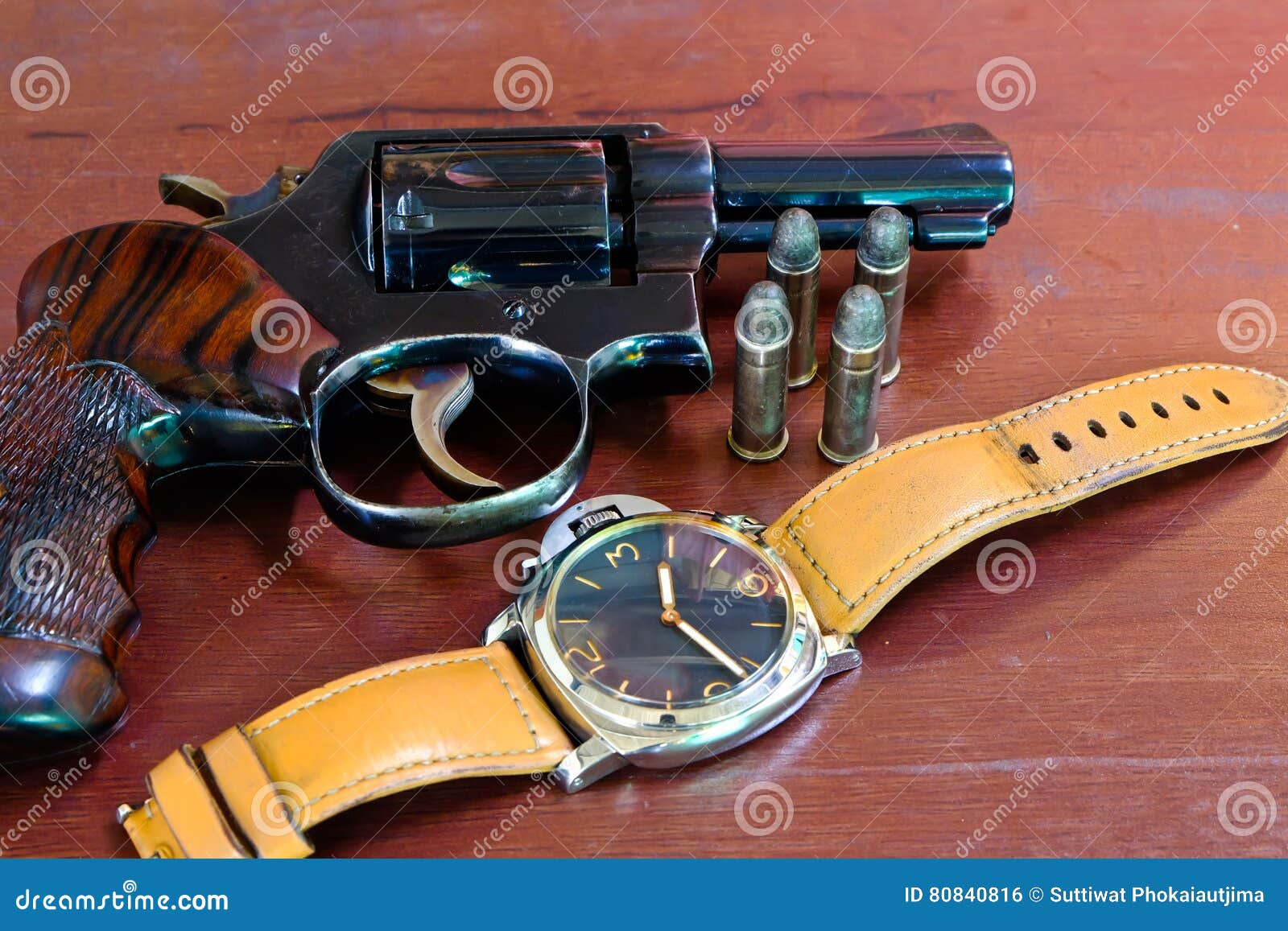 revolver with bullets on brown wooden tables and clocks