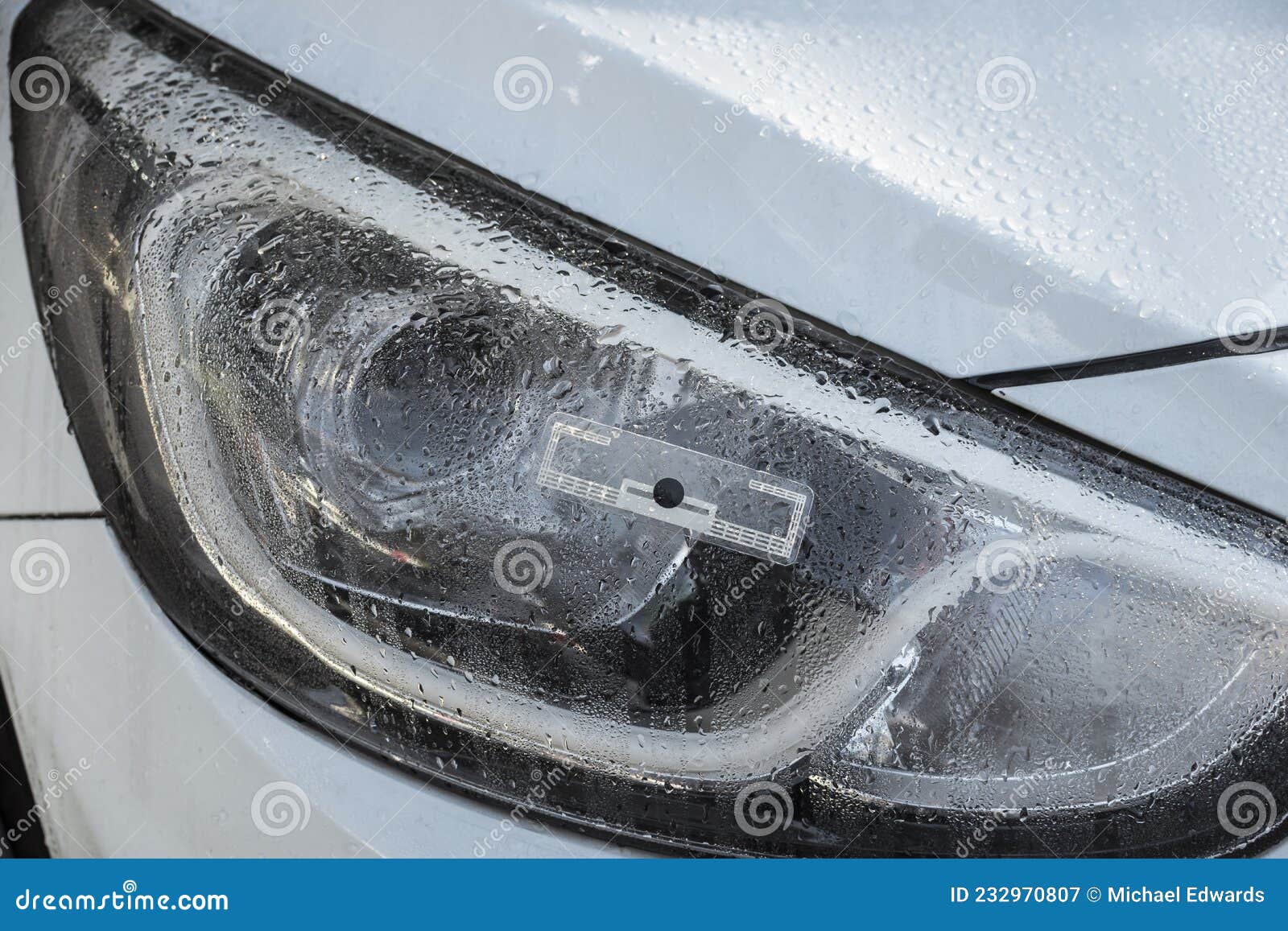 An RFID Tag Sticker on the Headlight of a Pearl White Car Stock Image