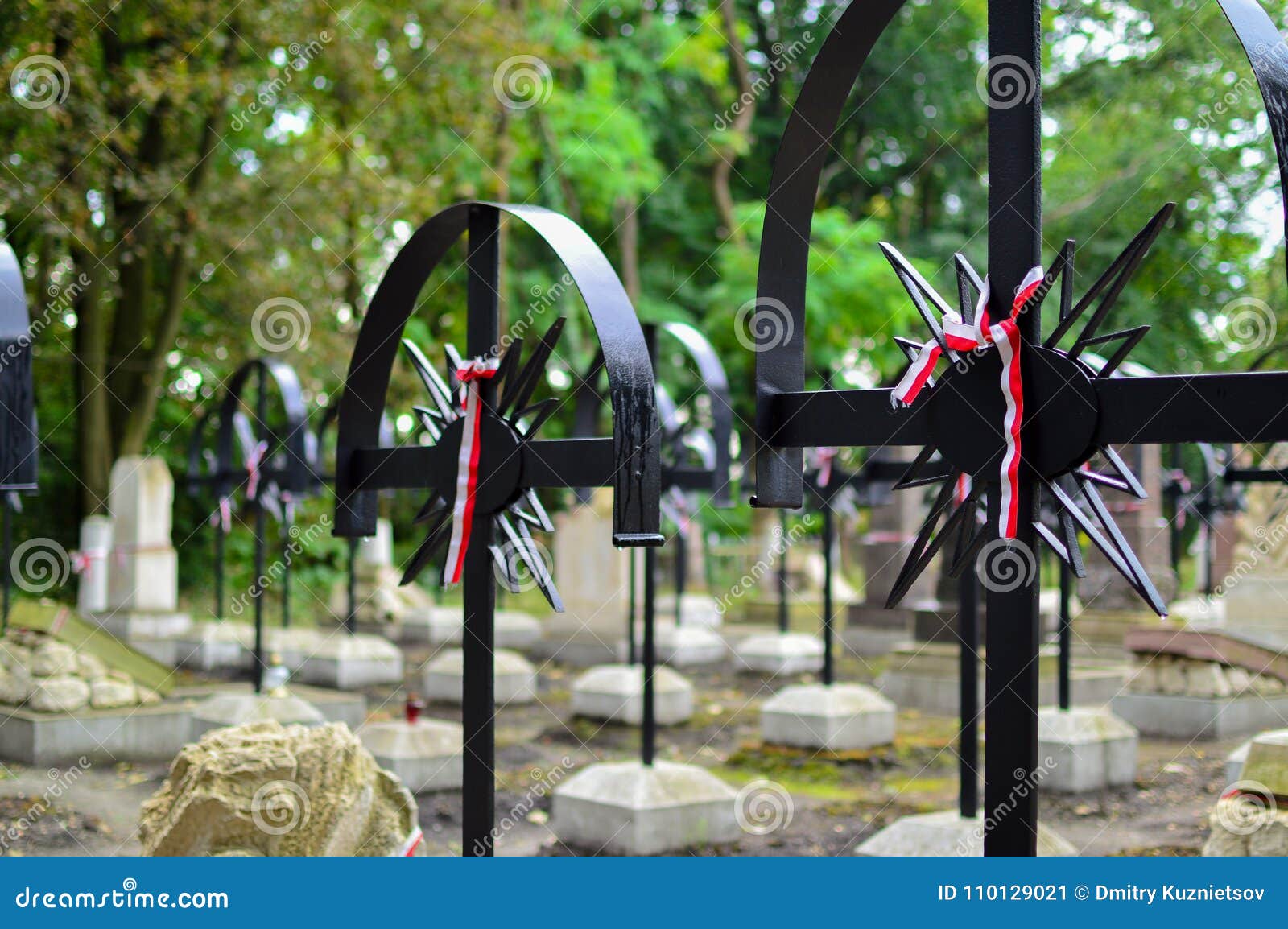 ribbon with national colours of poland tied up to the old cross on the cemetery. rebelion uprising concept.