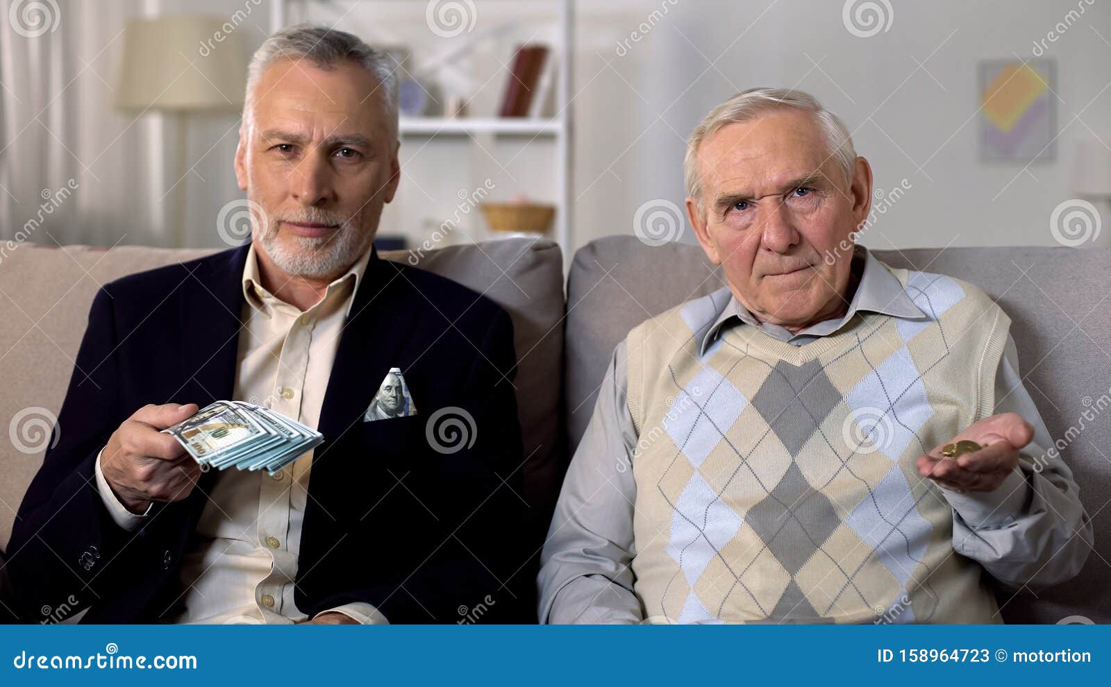 rich elderly man showing bunch of dollars, poor senior friend showing coins