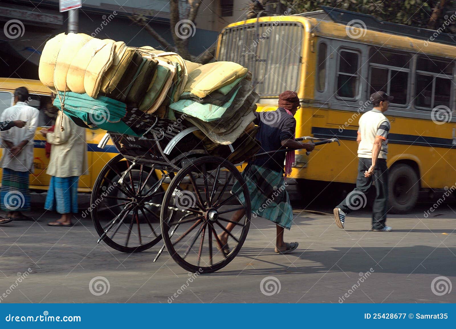 June 27,2012 Kolkata,West Bengal,India,Asia-The rickshaw puller works as long as the businesses are open and their are goods to deliver.