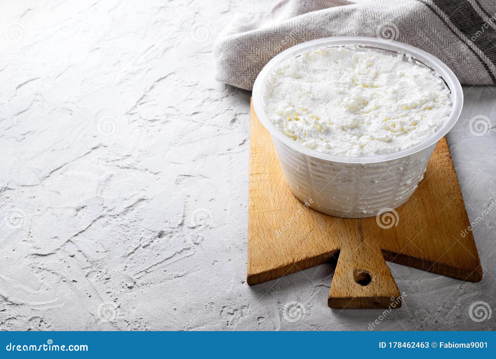 Ricotta Cheese and Wooden Cutting Board on White Plaster Background