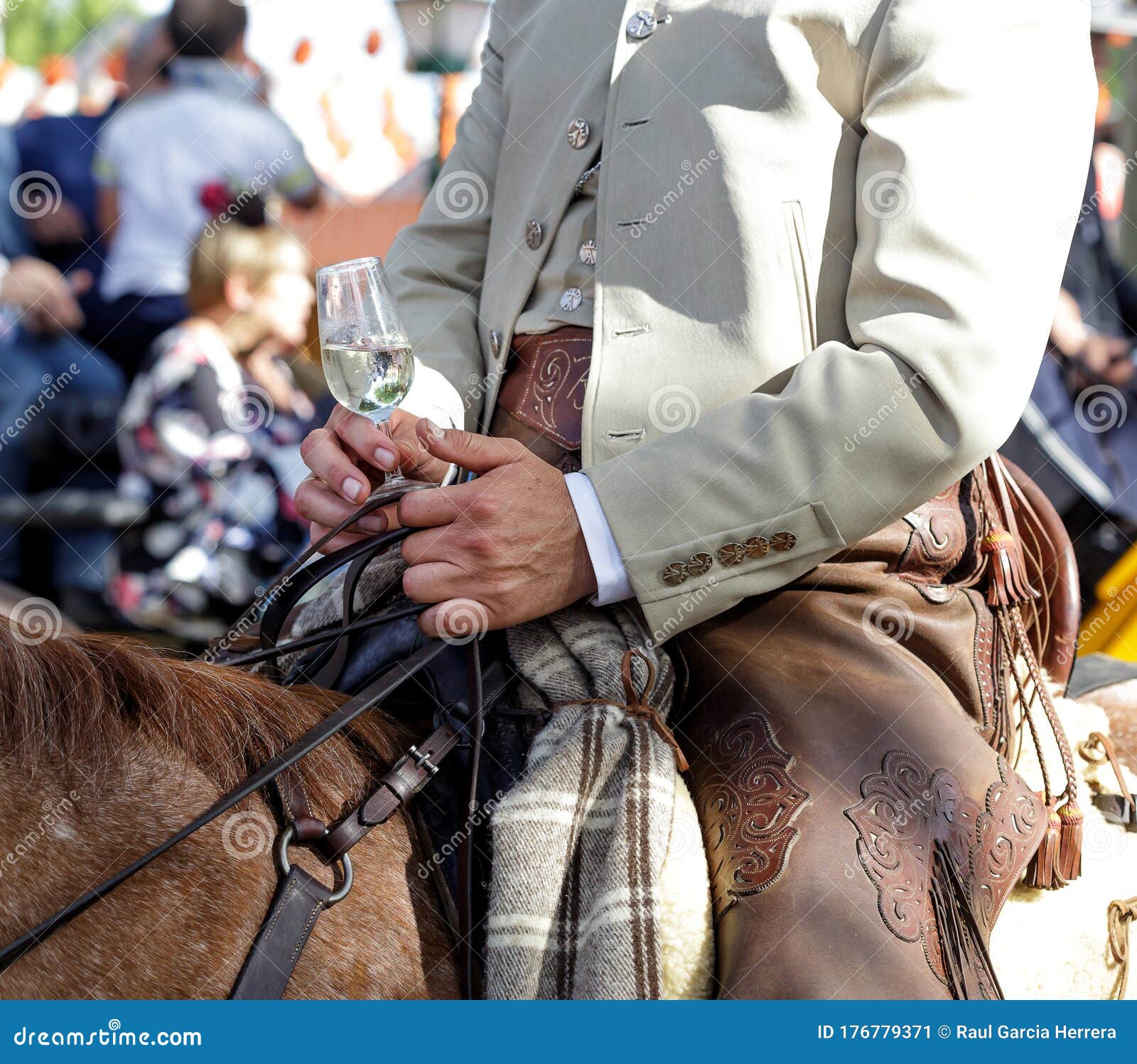 rider on horseback dressed in traditional costume and holding glass of fino sherry manzanilla sherry at the april fair