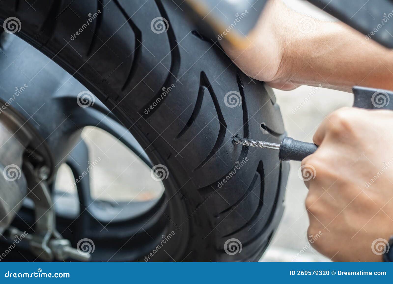 rider use tire plug kit and trying to fix a hole in tire's sidewall ,repair a motorcycle flat tire in the garage. motorcycle