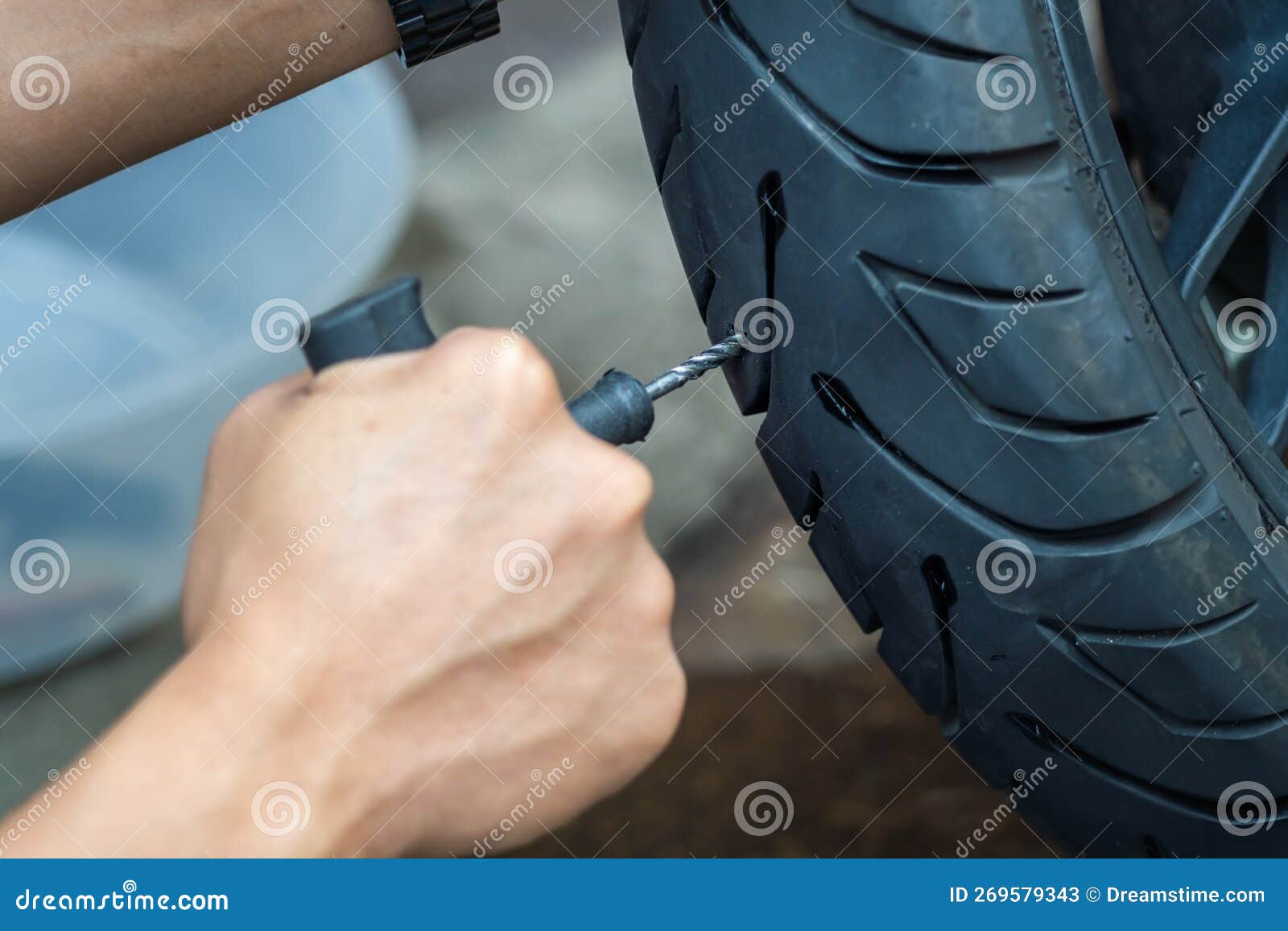rider use tire plug kit and trying to fix a hole in tire's sidewall ,repair a motorcycle flat tire in the garage. motorcycle