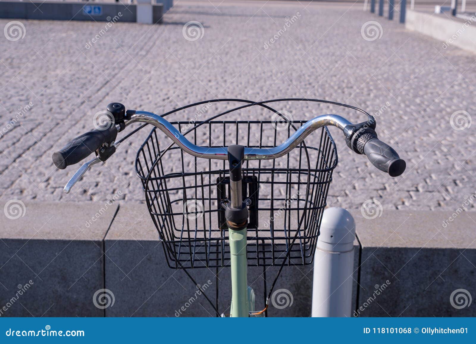 A Riders Eye Viewpoint of a Set of Curved Handlebars and a Basket on a Green Bicycle Stock Photo