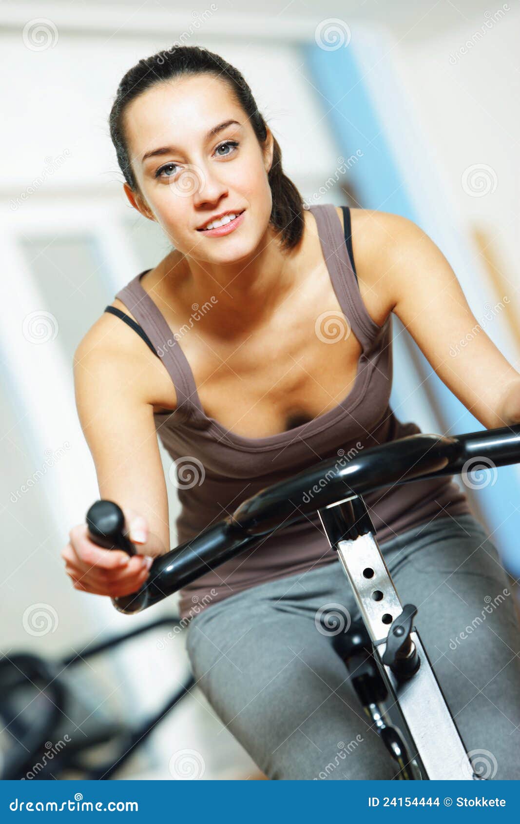 Riding an exercise bike stock photo. Image of health - 24154444