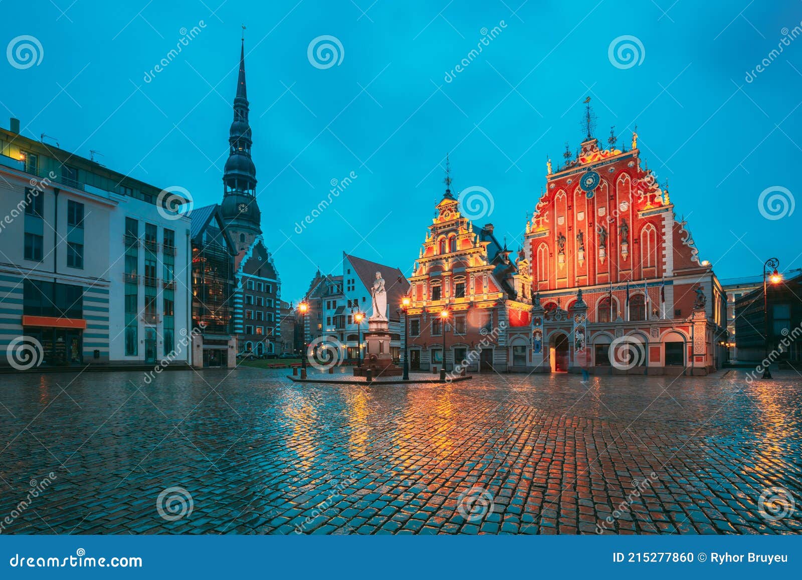riga, latvia. scenic town hall square with st. peter's church, schwabe house, house of blackheads during night rain