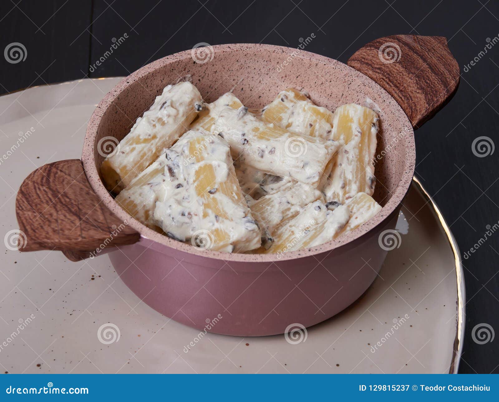 rigatoni with cream, gorgonzola and olives, on a dark brown board