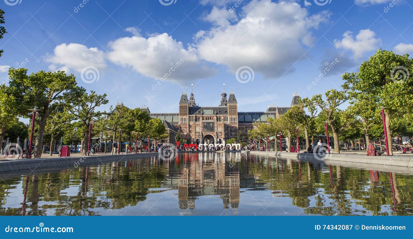 Rijksmuseum Amsterdam z odbiciem w pont. Rijksmuseum Amsterdam widzieć od Museumsquare Odbicie w pont wykładającym z drzewami