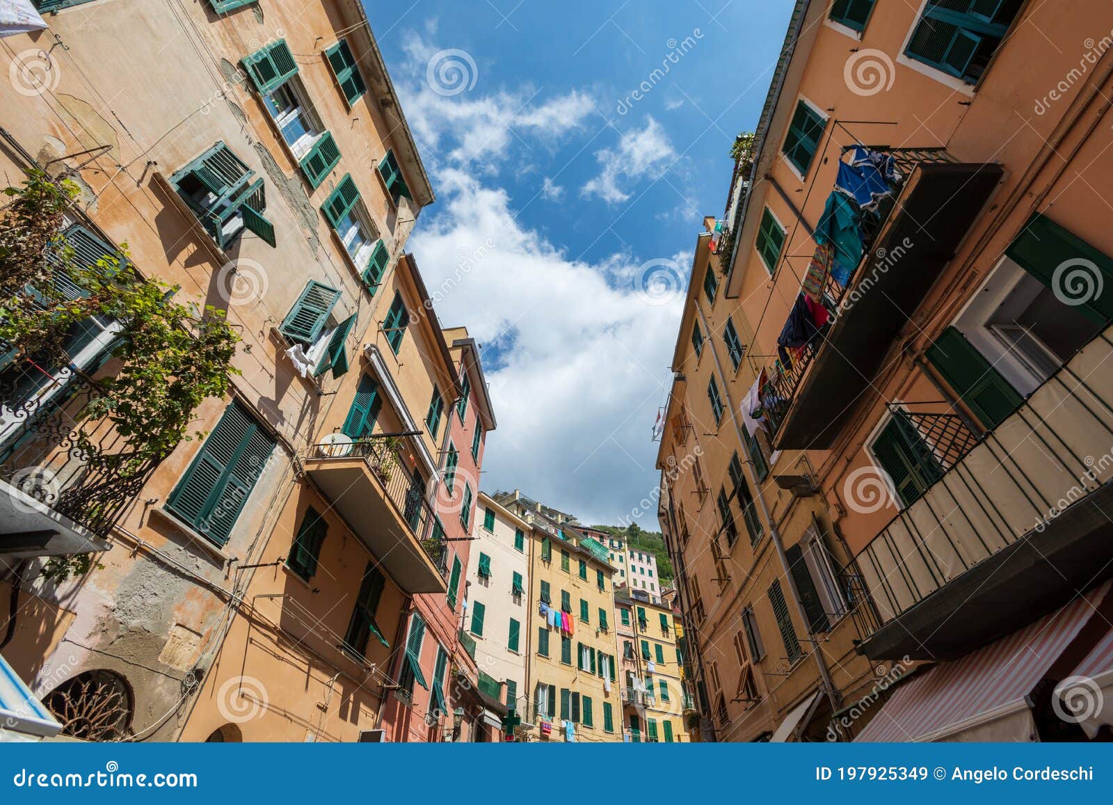 Perspective view of colored houses in the city of Riomaggiore in Italy. Blue sky. Palaces with balconies and windows.