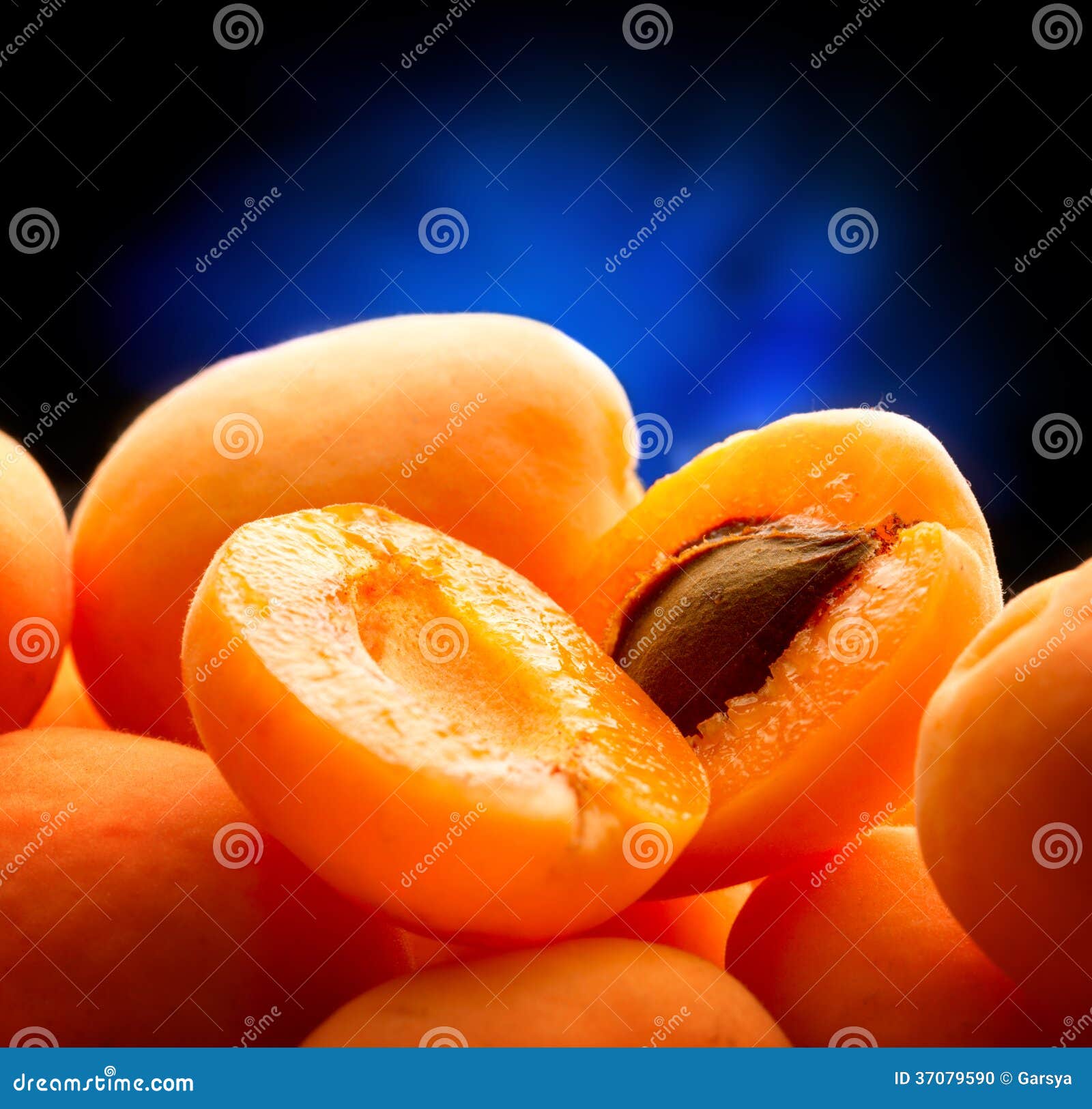 Heap of ripe apricots on blue