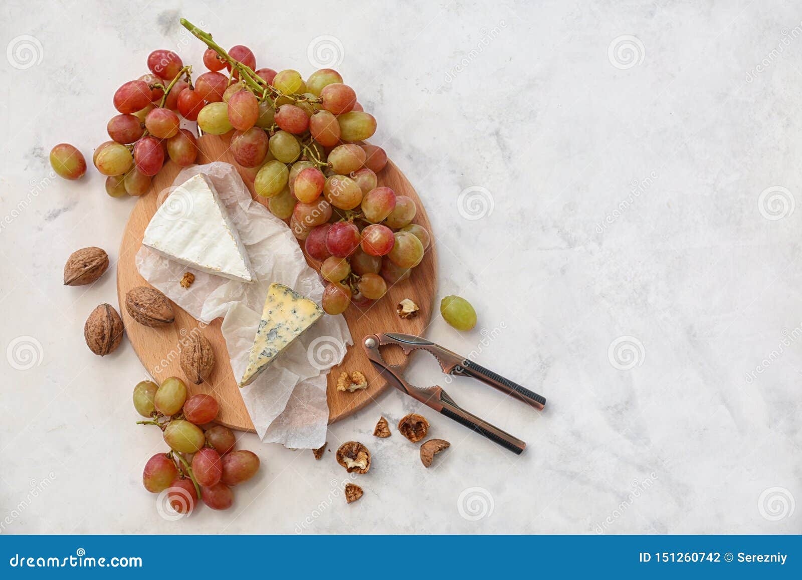 Ripe Juicy Grapes with Cheese and Walnut on Light Table Stock Photo