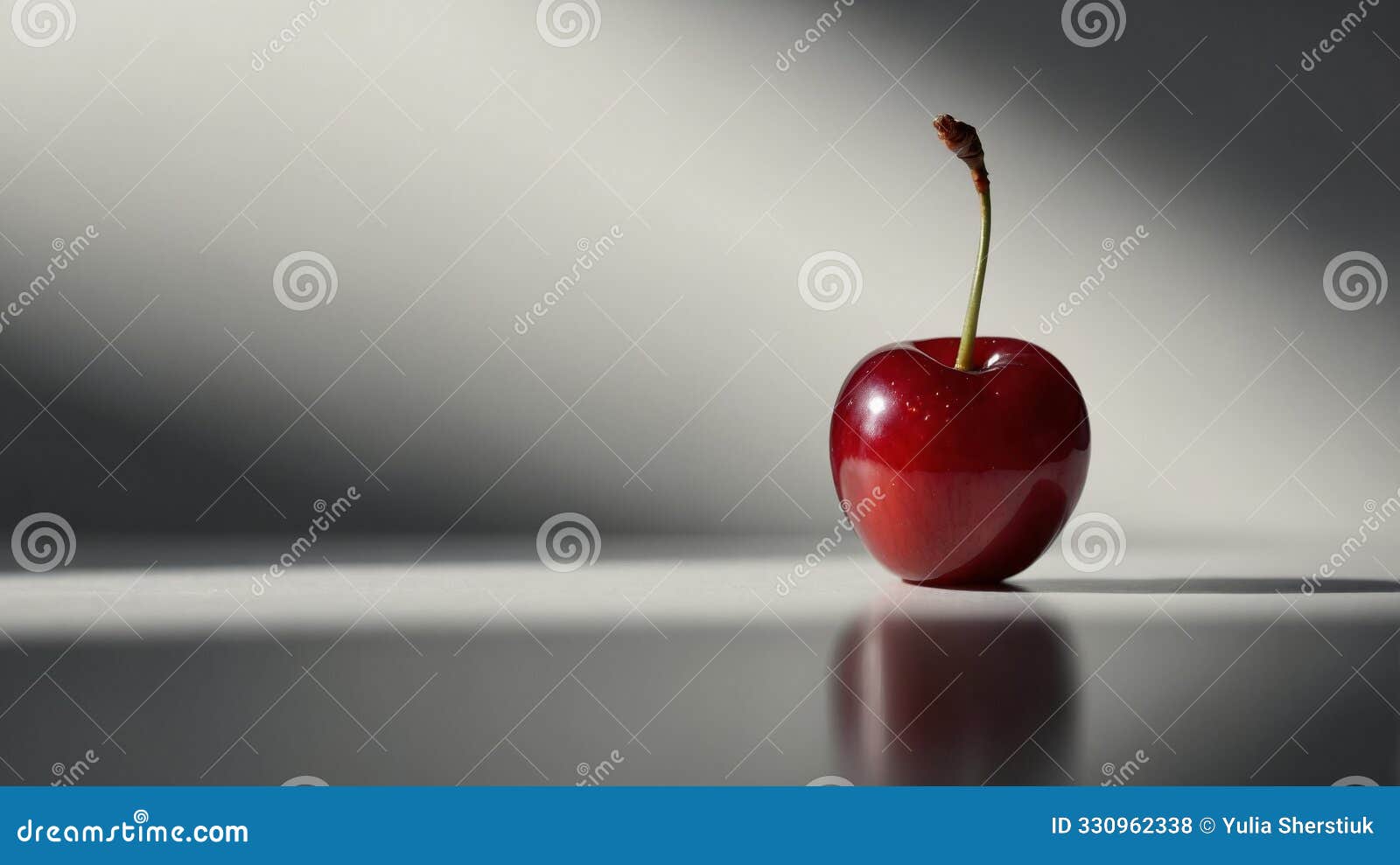 a ripe solitary cherry with a glossy sheen and intact stem casts a playful shadow this image encapsulates simplicity and