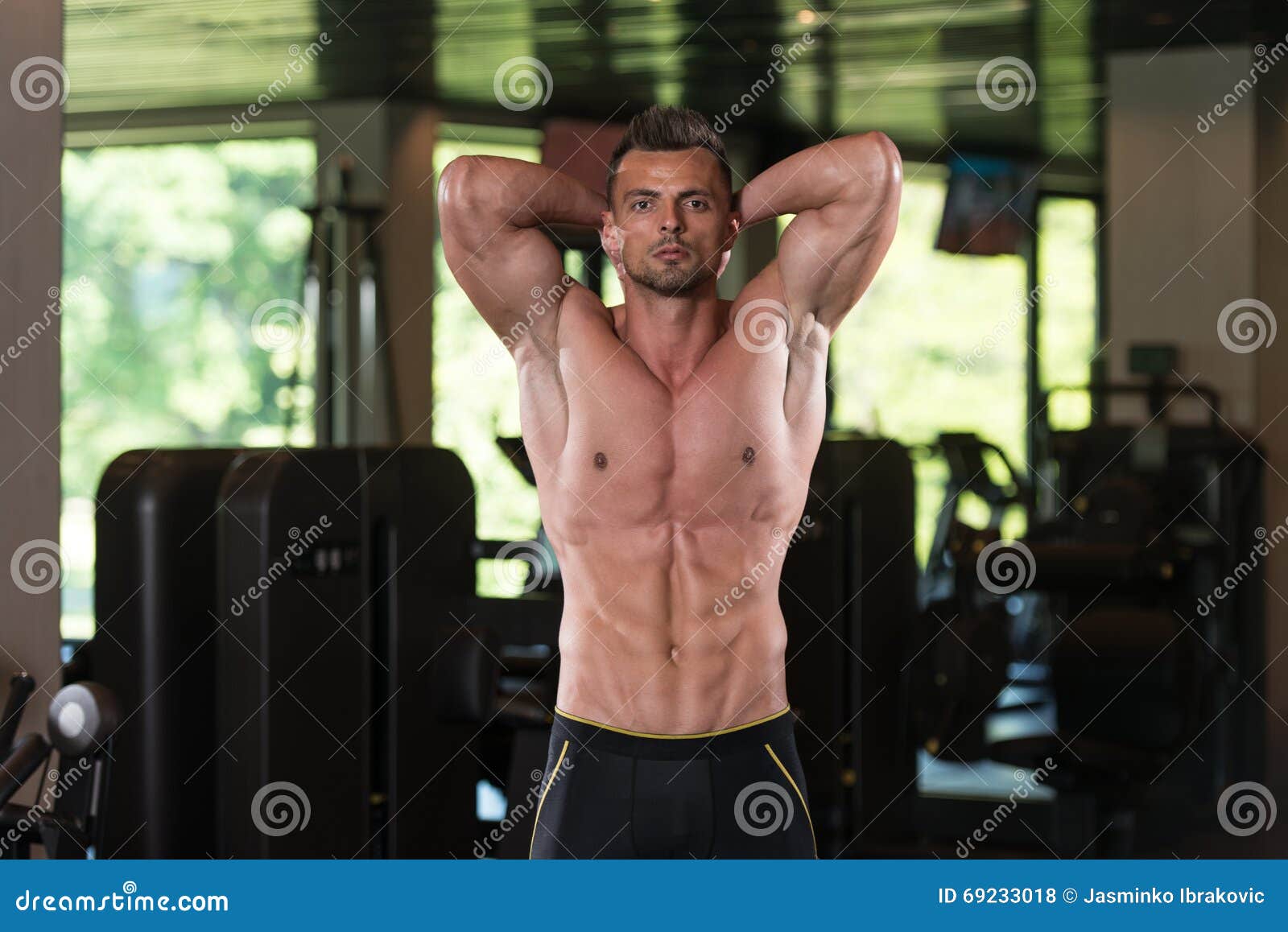 Toned and ripped lean muscle fitness man lifting weights 