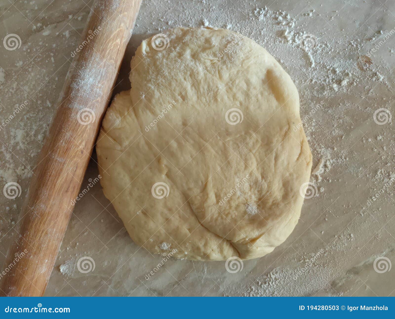 risen or proved yeast dough with rolling pin top view. dough and flour.