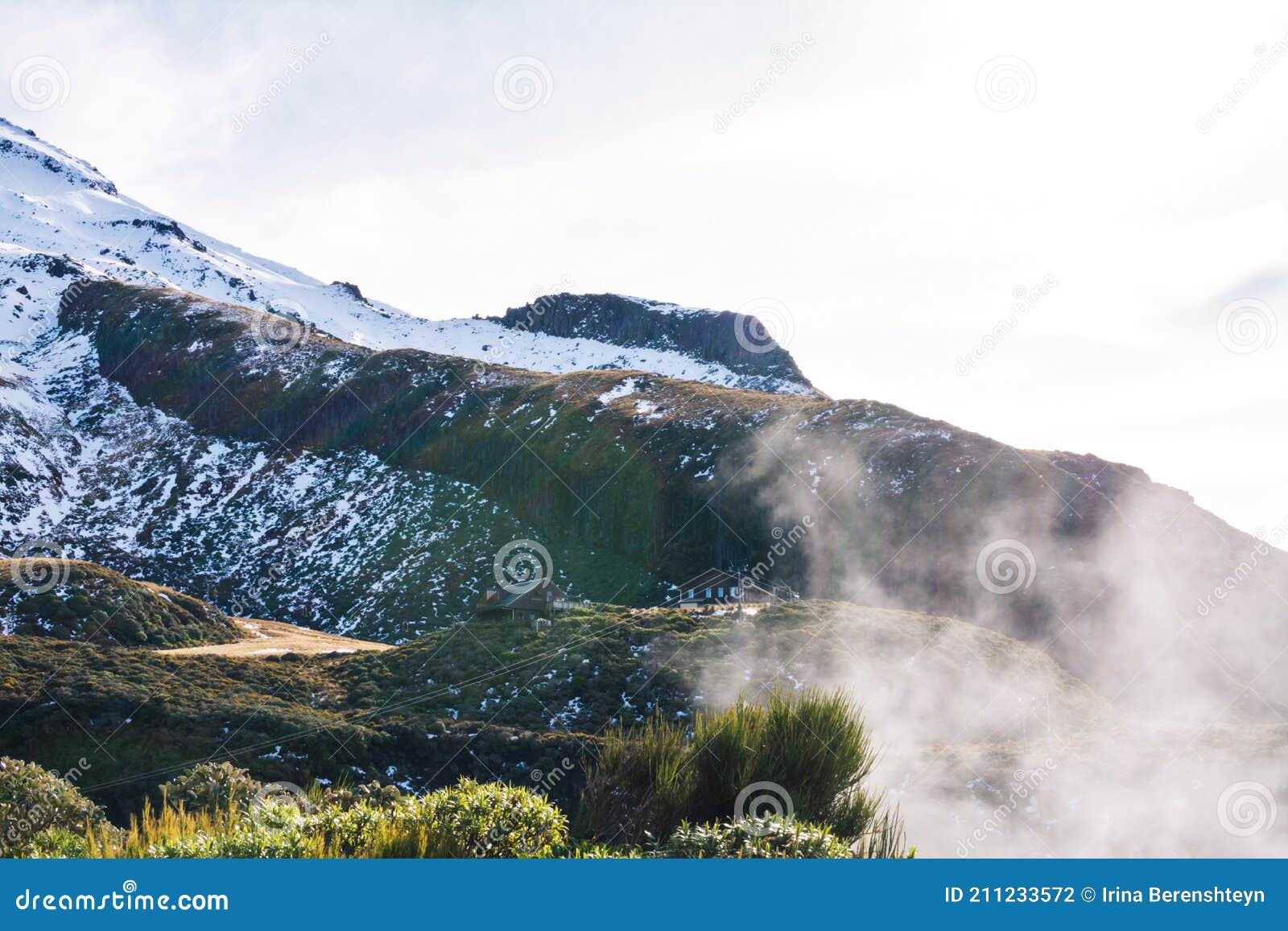 rising fog is about to hide wooden shelter huts at the base of mt taranaki skifield