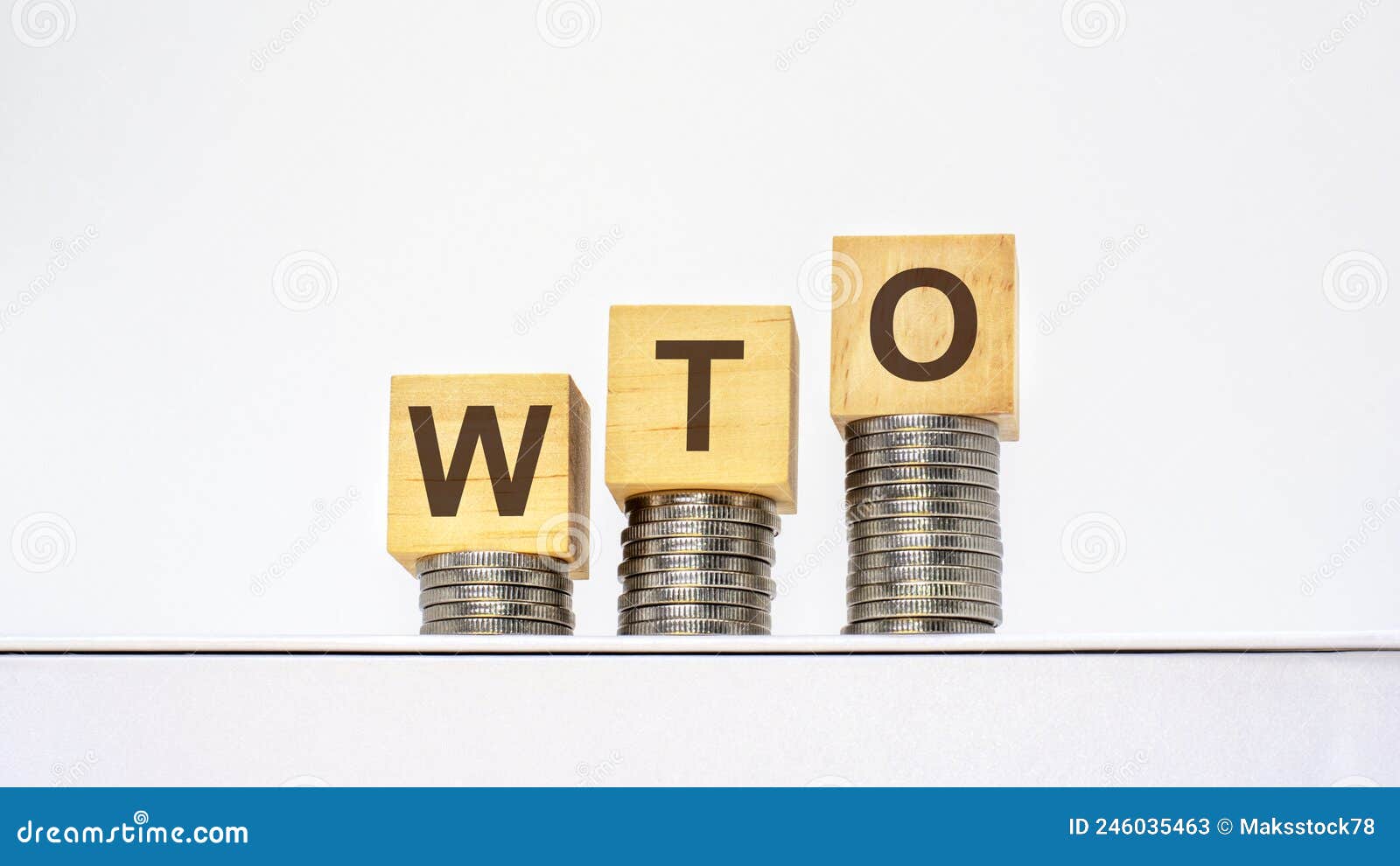 rising stacks of coins with the letters wto on the wooden cubes, white background, business and finance concept