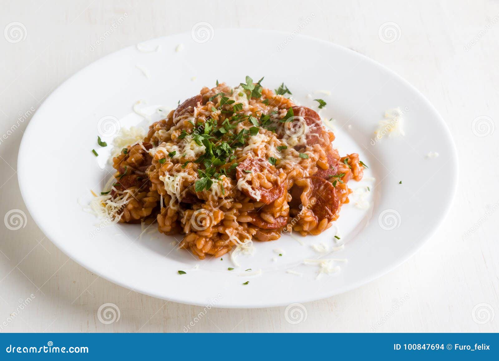 Risotto del chorizo con il pomodoro ed il vino rosso sul piatto bianco