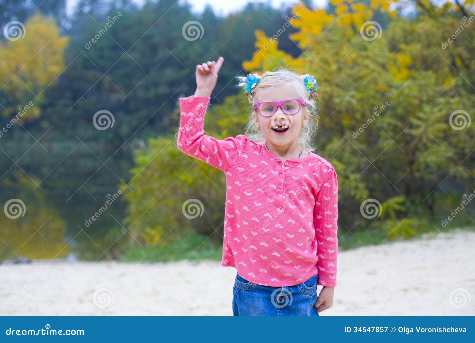 Ritratto divertente della ragazza emozionale in vetri rosa. Ragazza contorcentesi divertentesi in vetri rosa all'aperto