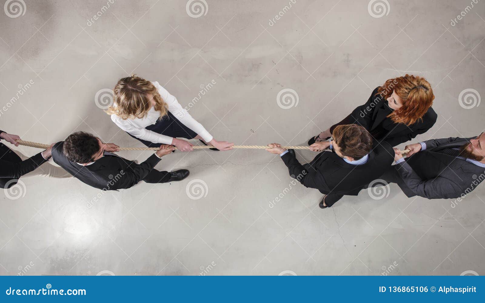 rival business man and woman compete for the command by pulling the rope