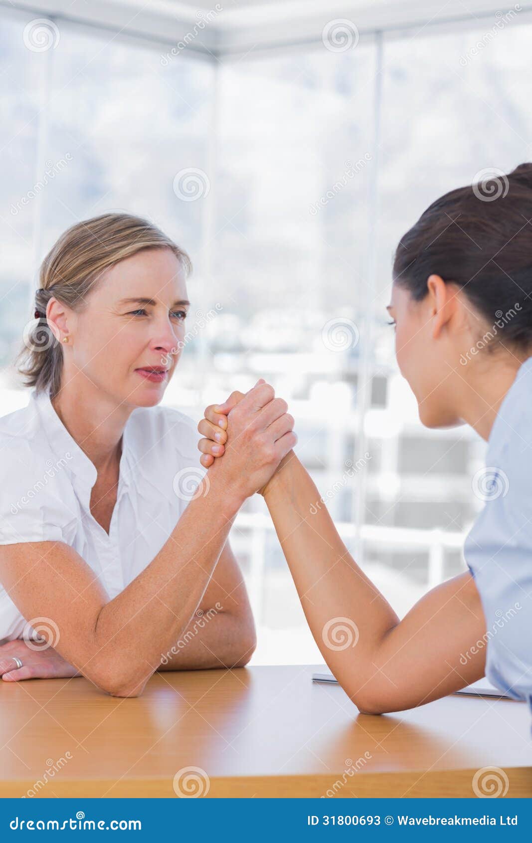 rival businesswomen having an arm wrestle