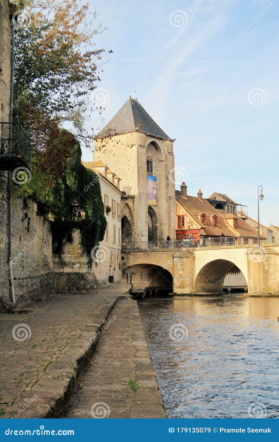 the river loign and the main gate of the medieval city, moret-sur-loign, france