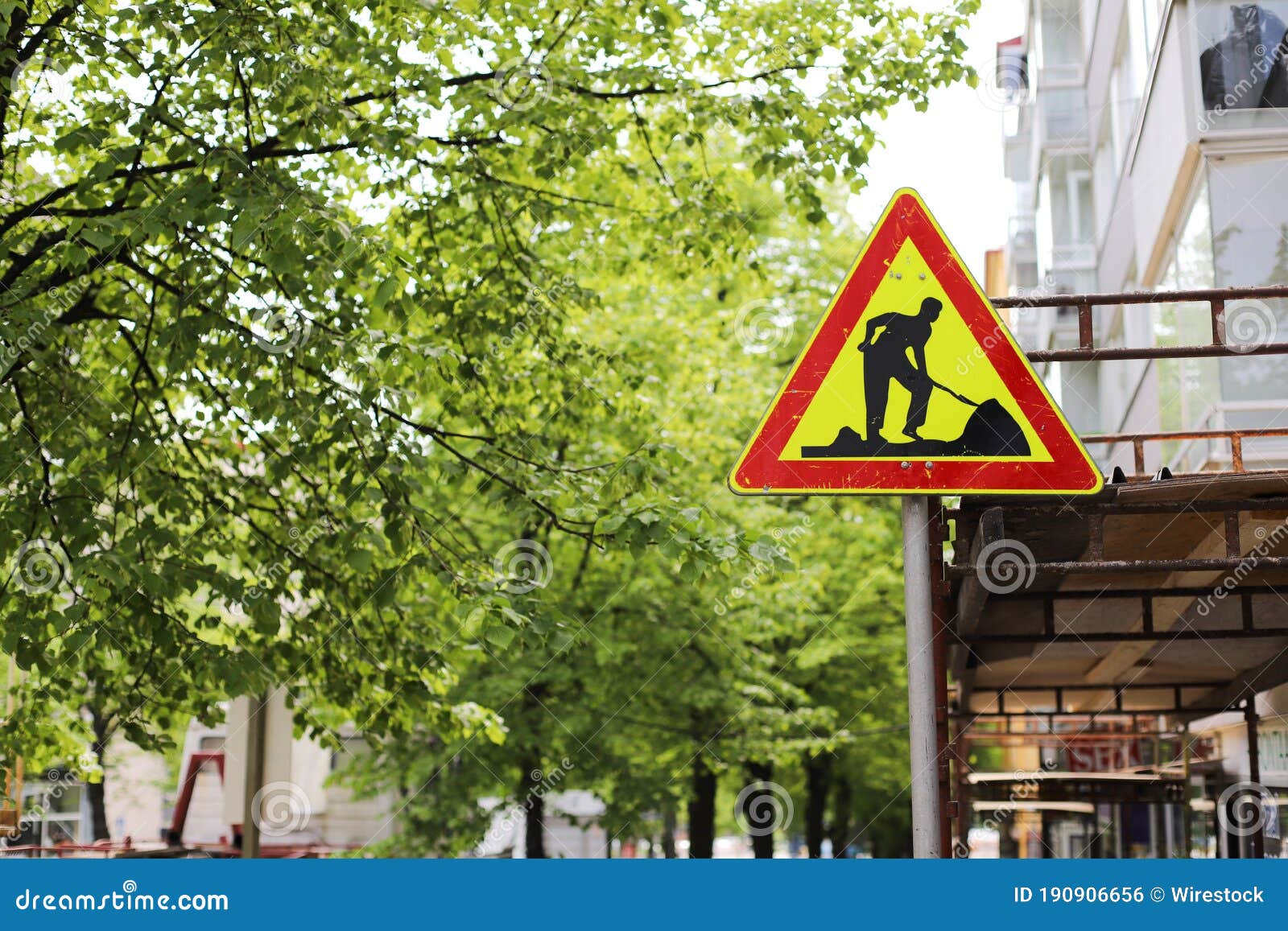 Road Construction Sign on the Street with Trees in the Background Stock
