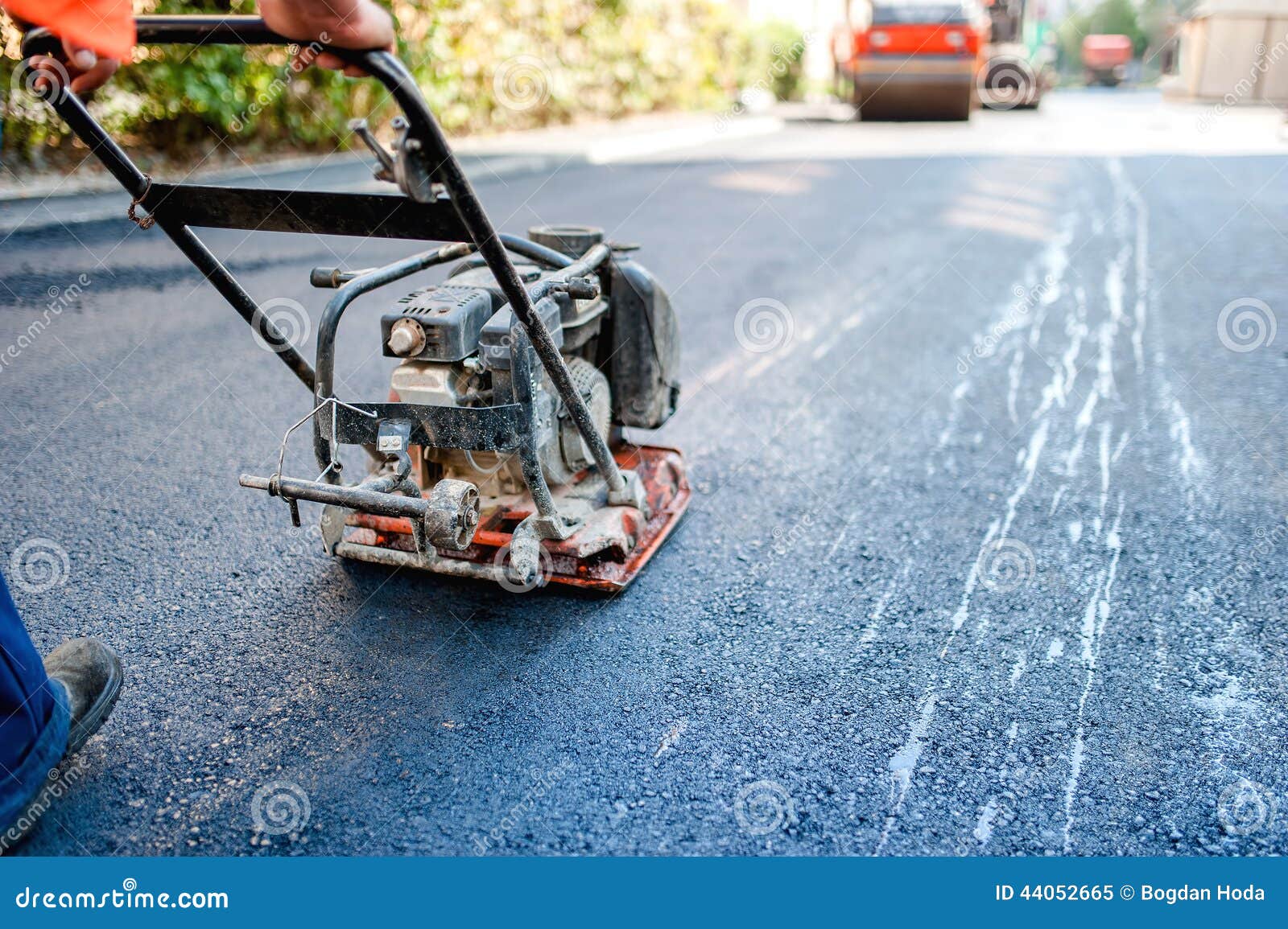 road construction with worker paving the fresh bitumen or asphalt