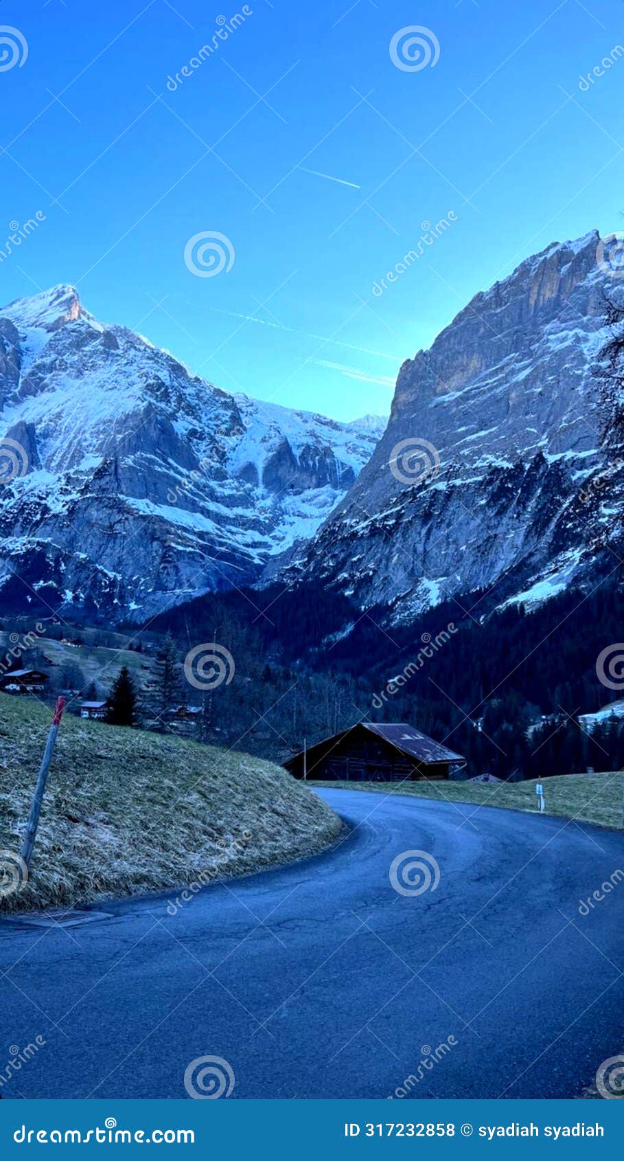 the road is flanked by two beautiful snowy mountains