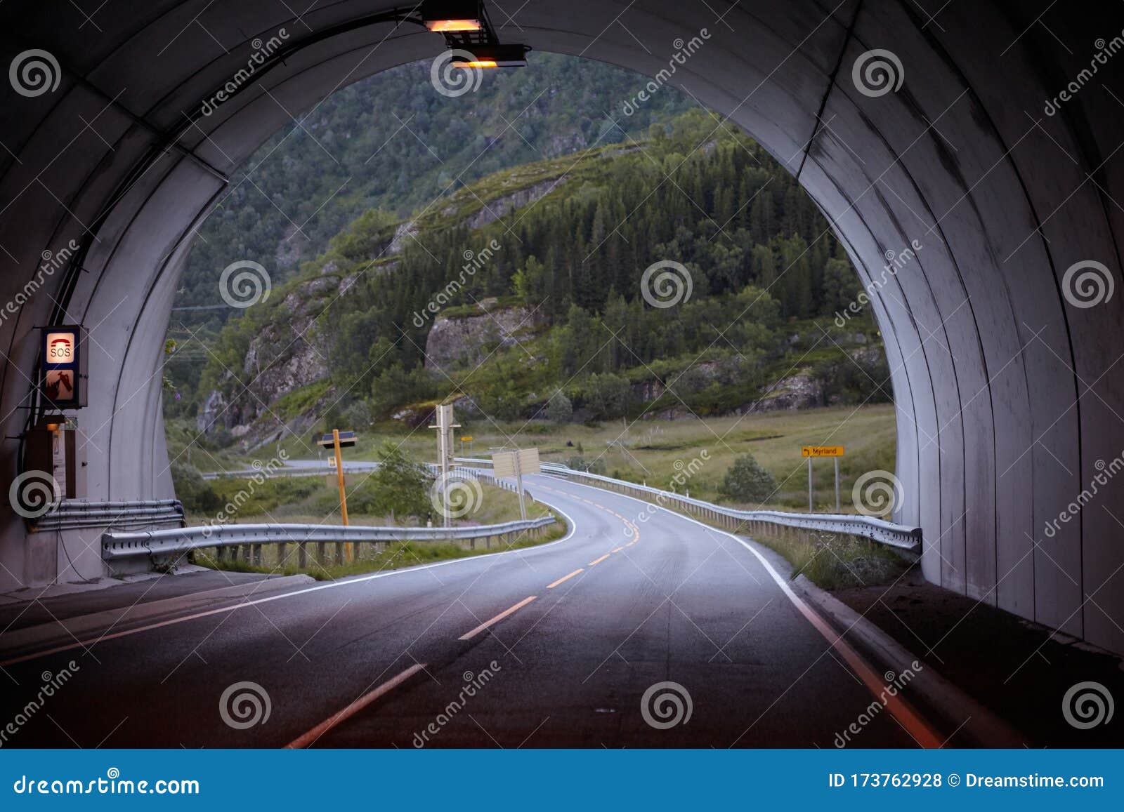 road in the mountains with a tunnel. the road goes into the tunnel, the markings on the road
