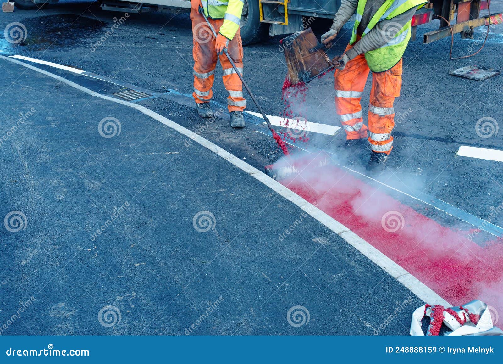 Road Workers Applying Hot Red Road Marking Paint on New Build Road