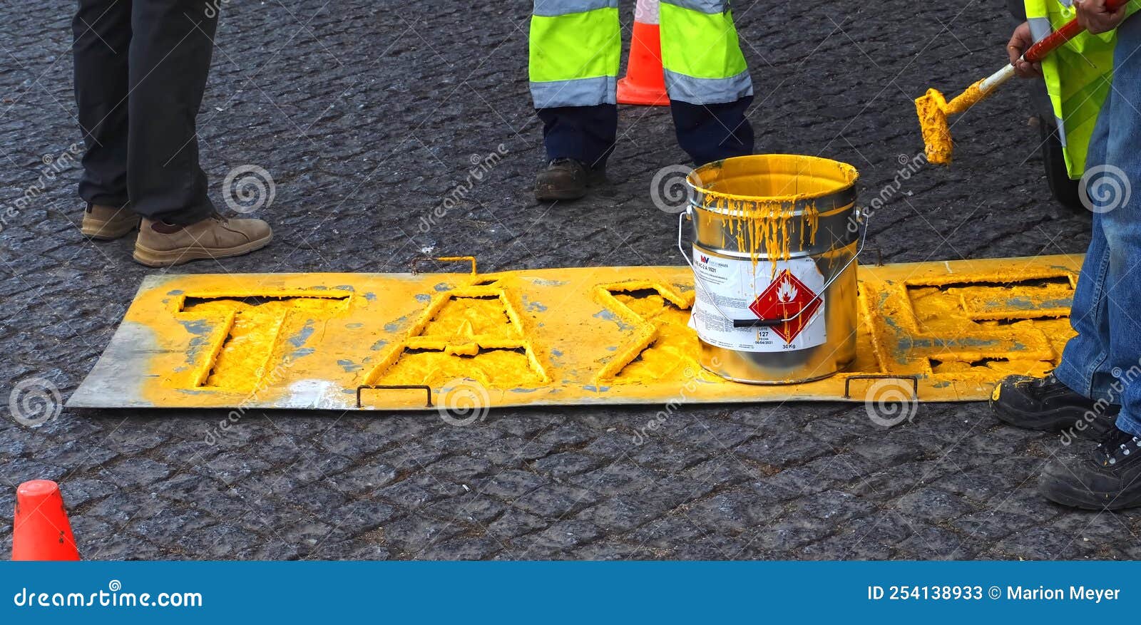 road workers paint lane markings for taxis with yellow marcas viales color in portugal
